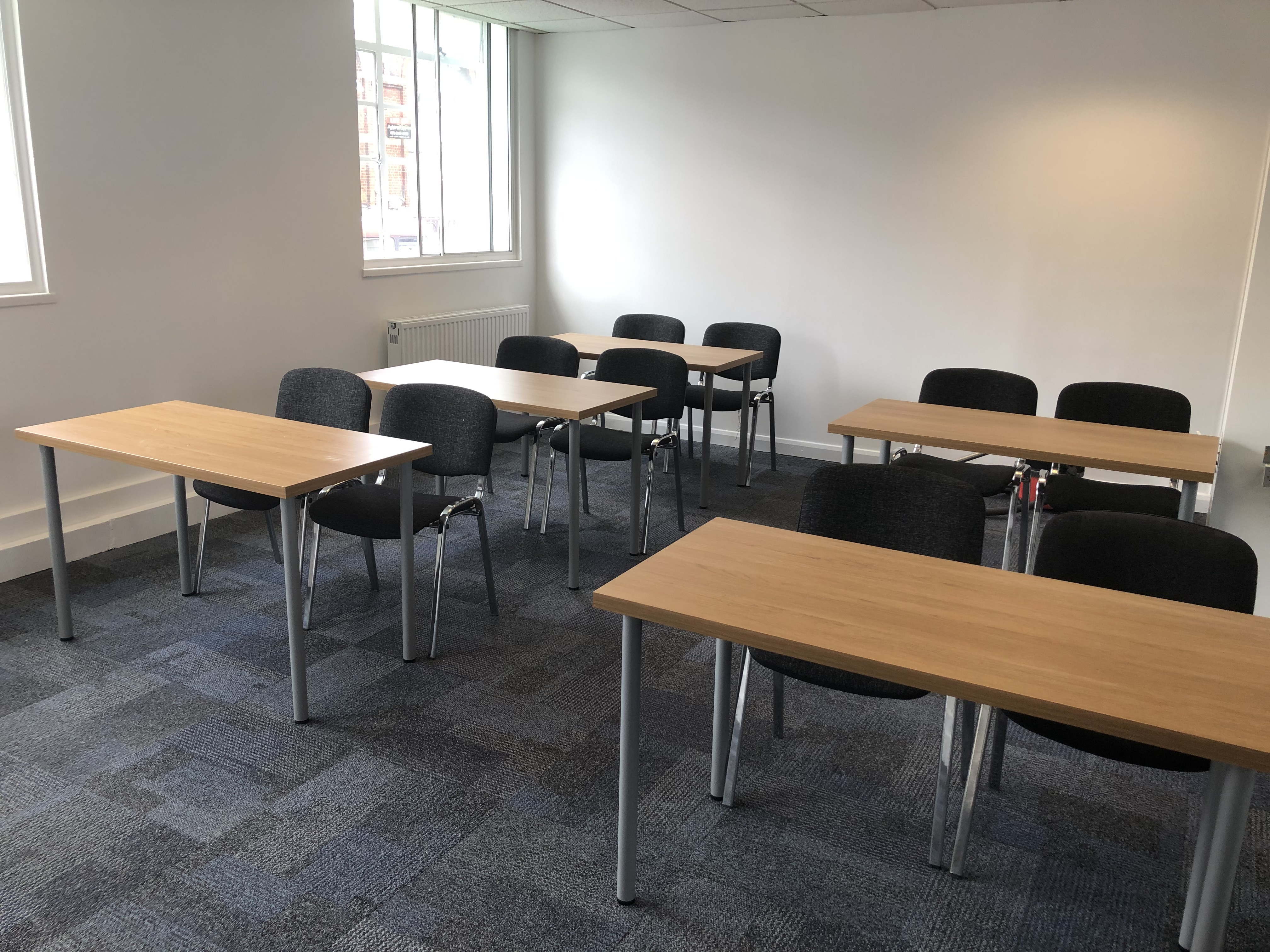 Seminar room with tables and chairs, ideal for workshops and training sessions.