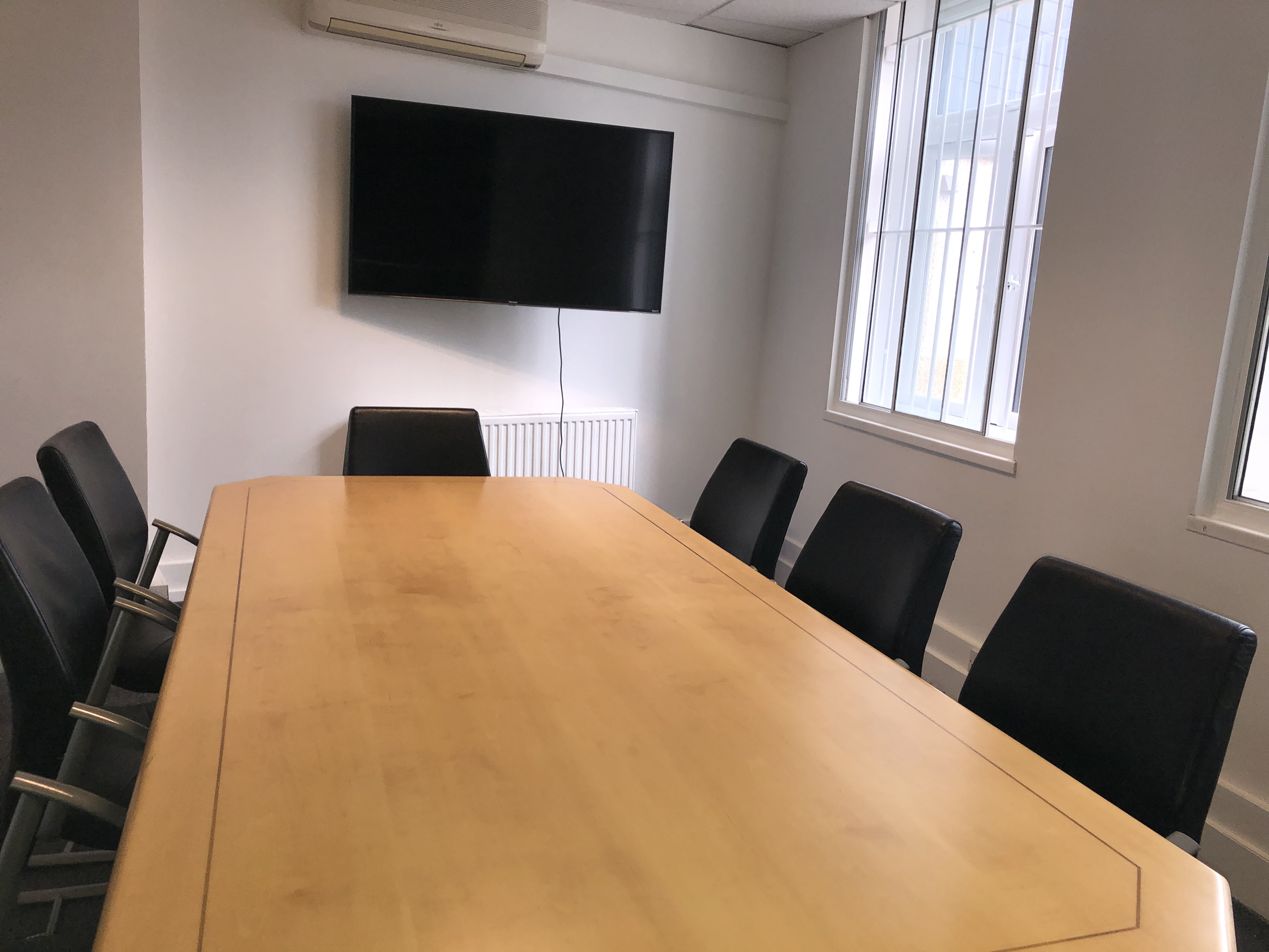 Modern board room with wooden table and leather chairs, perfect for leadership meetings.