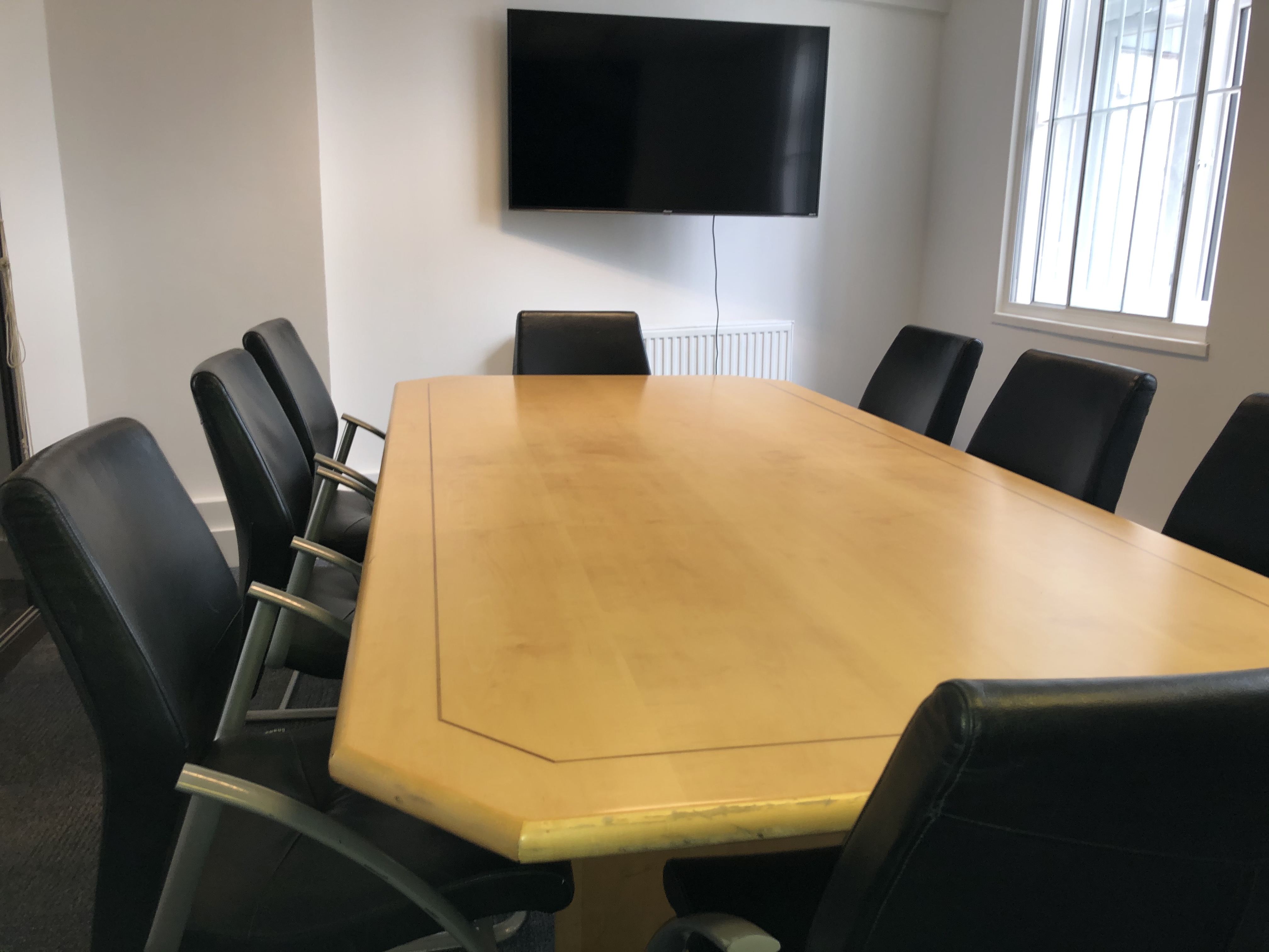 Board Room at School of Leadership with polished table, ideal for meetings and presentations.