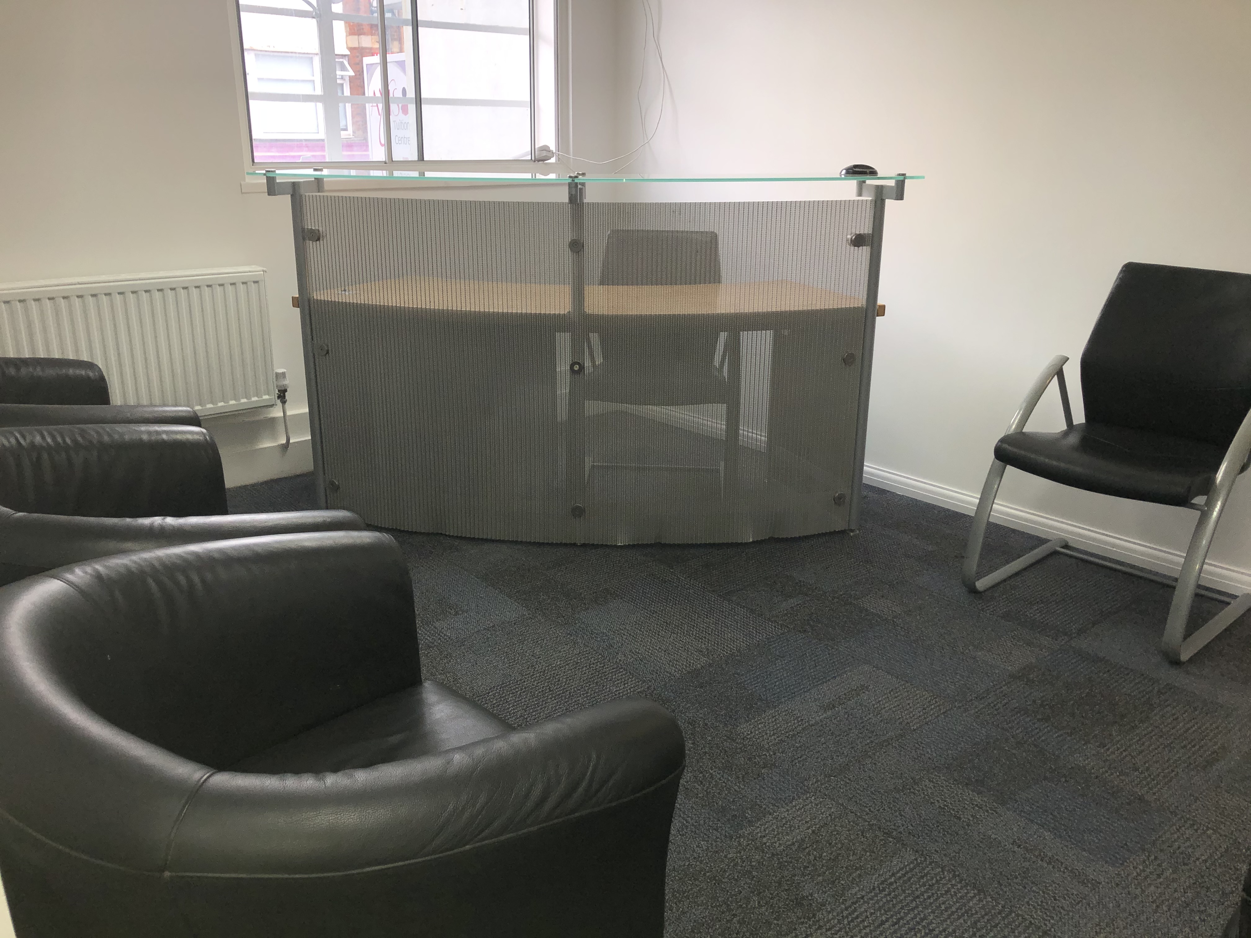 Minimalist board room with glass partition for collaborative meetings in leadership school.