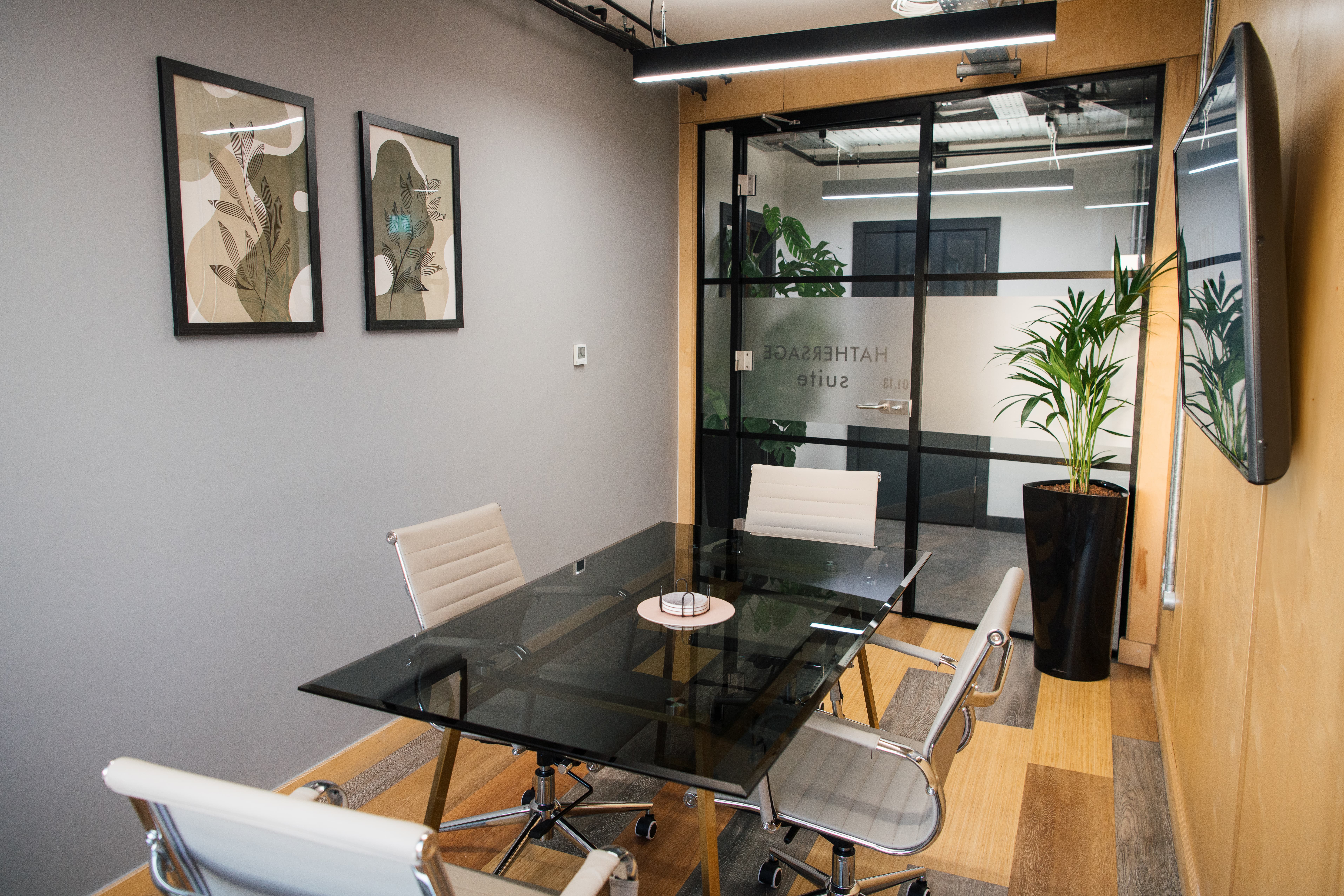 Modern boardroom with glass table for 4 in Wizu Workspace Hathersage Suite, perfect for meetings.