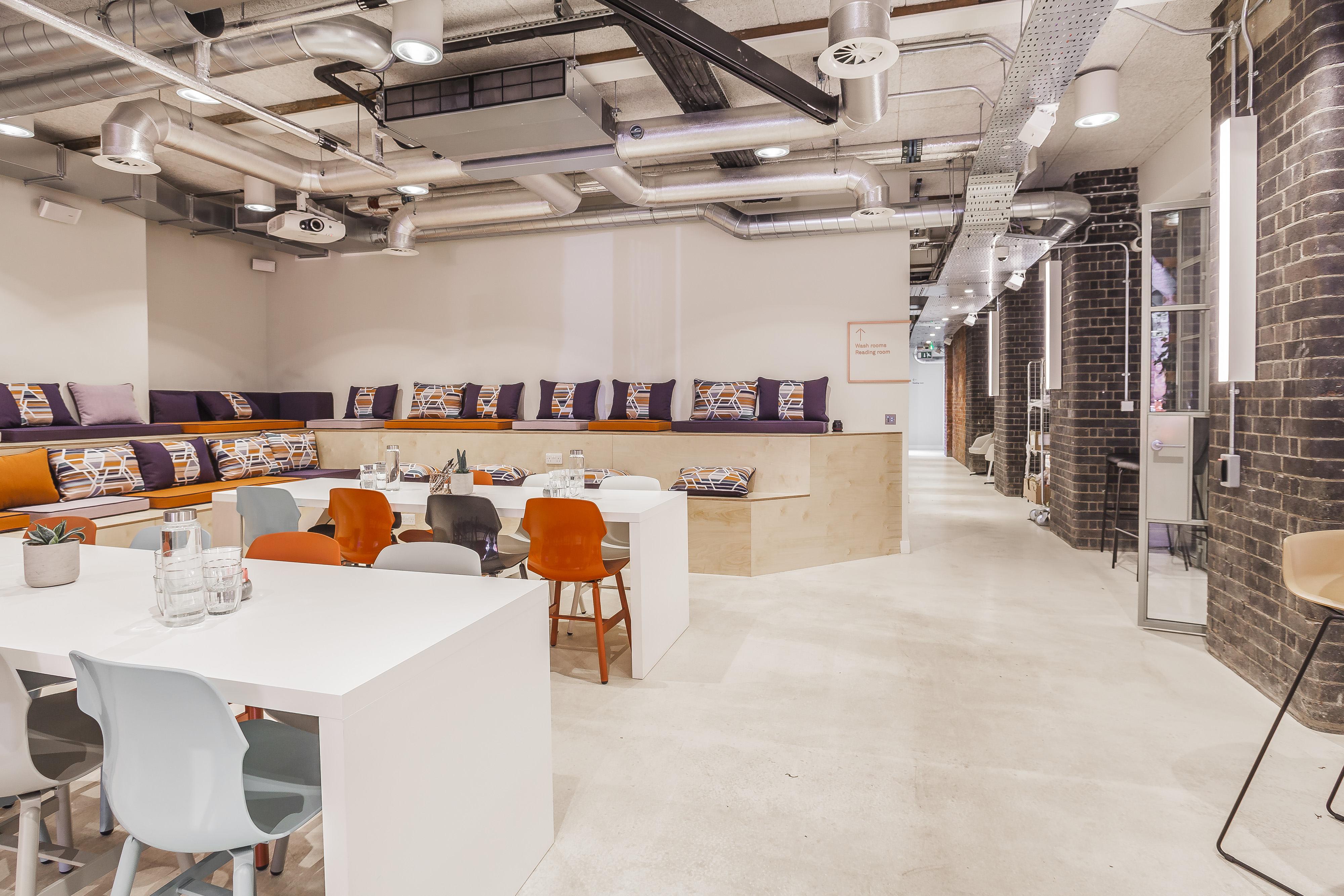 Industrial-chic breakout space with tiered seating for collaborative workshops and networking events.