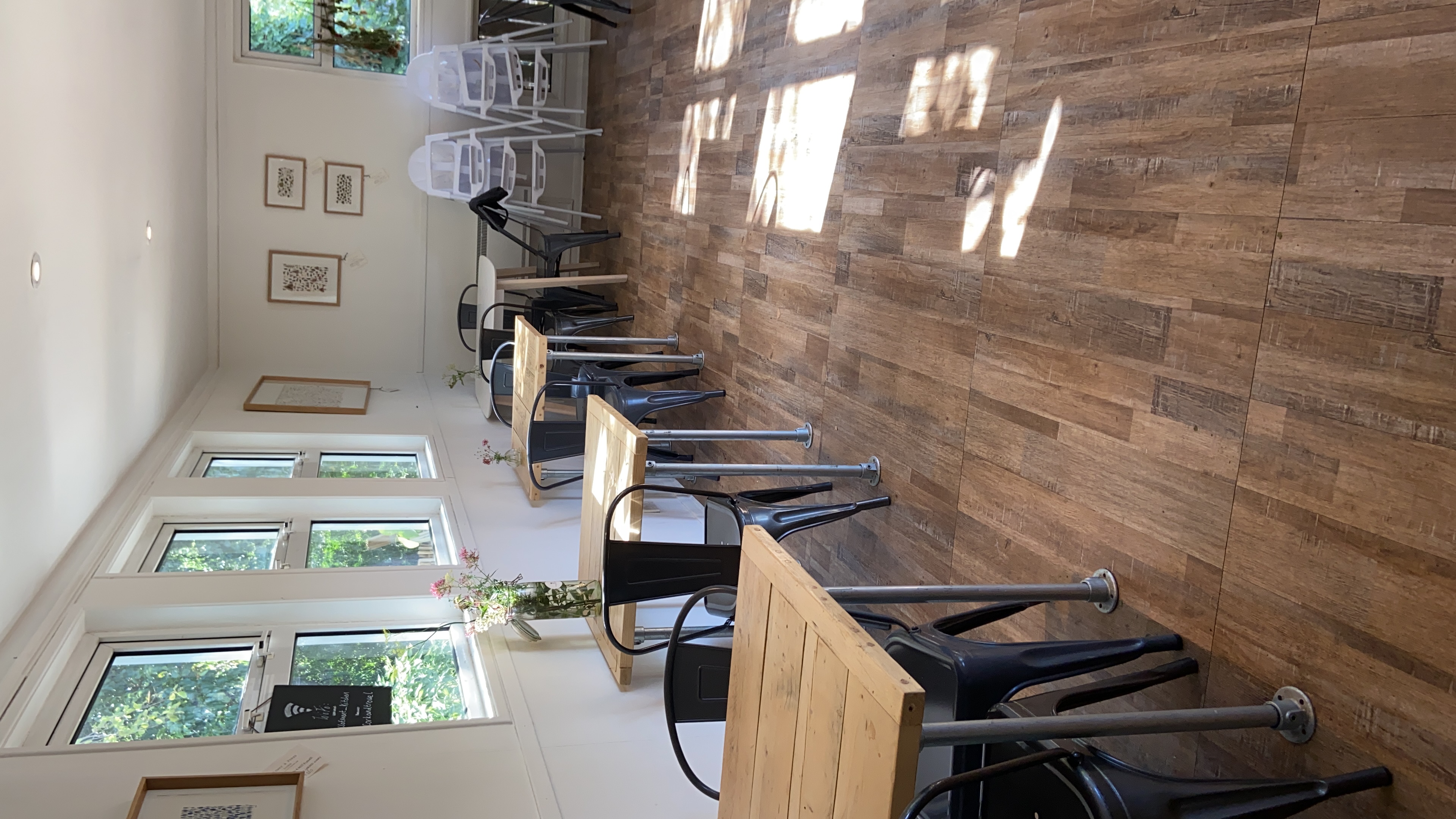 Versatile event space with wooden tables and metal chairs for casual meetings or gatherings.