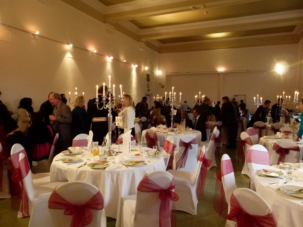 Indus Hall at Kala Sangam: elegant event space with white linens and pink sashes.