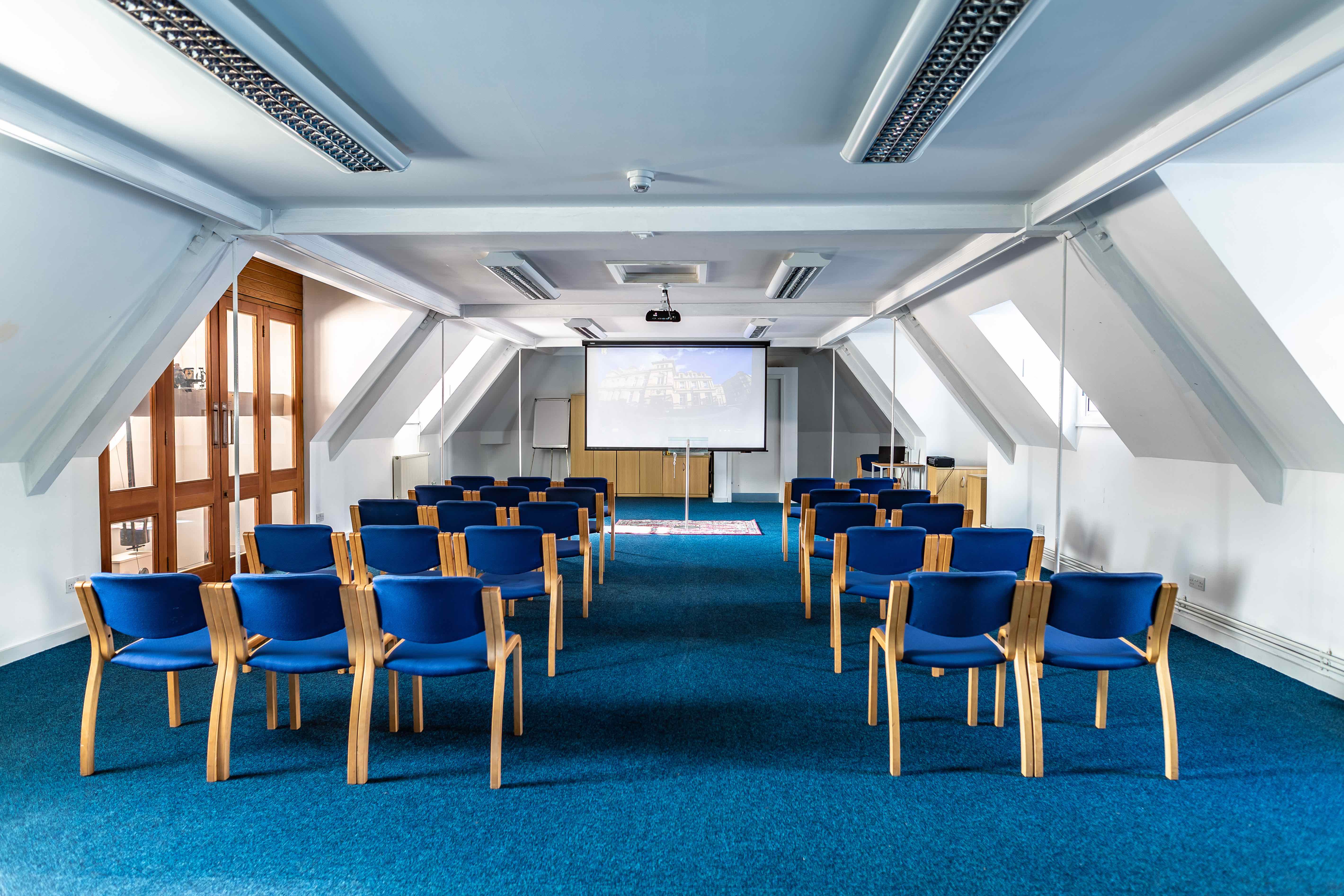 Clock Tower Suite at Kala Sangam: bright meeting space with blue chairs for workshops.