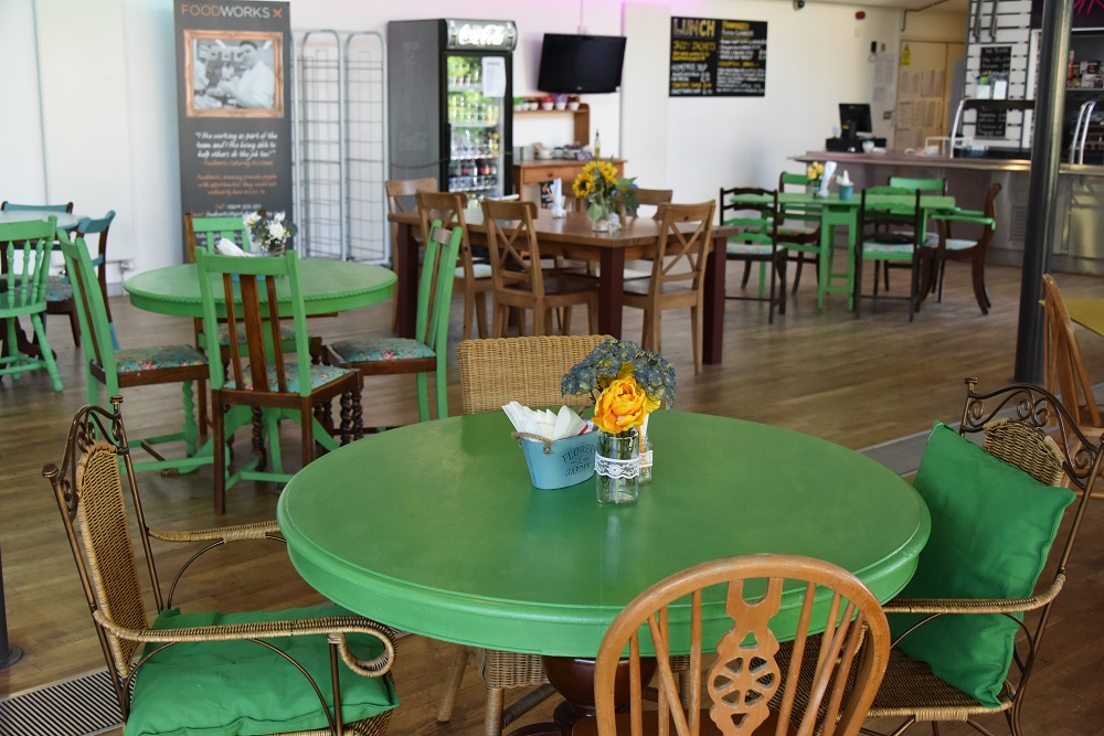 Rooftop Cafe at Kala Sangam: vibrant meeting space with green tables for gatherings.