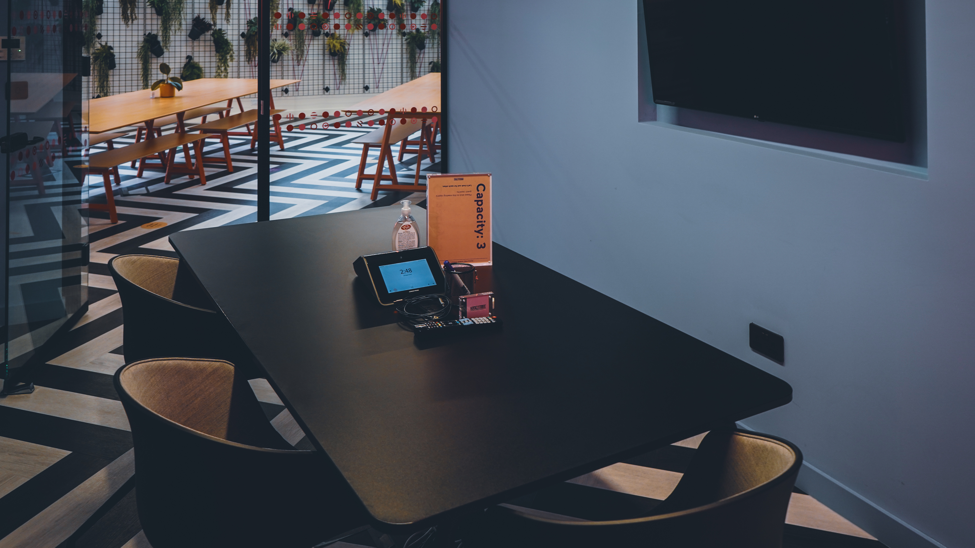 Modern meeting space in Milan with sleek black table, ideal for collaboration and creativity.