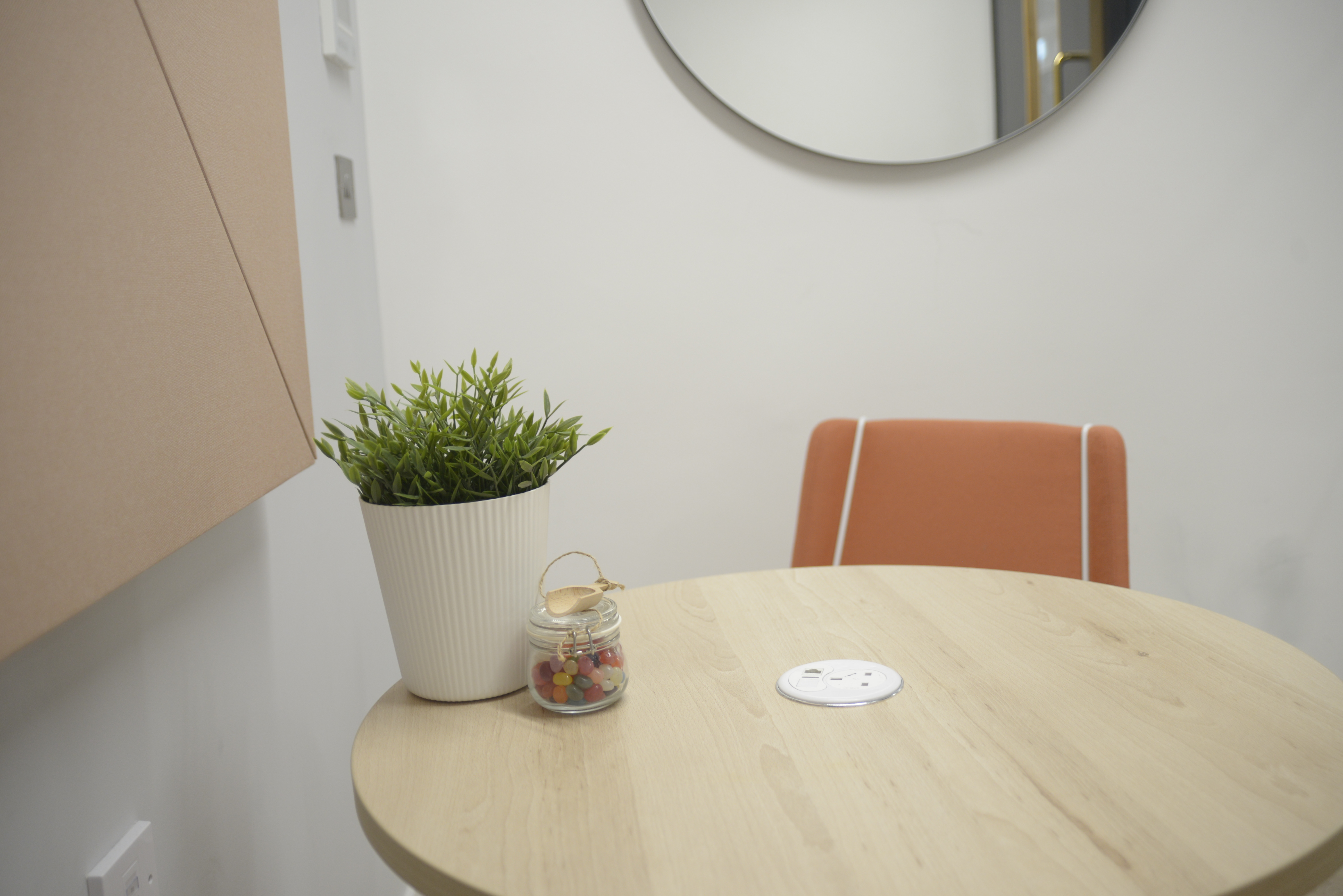 Modern Rey Meeting Room with round table and orange chair for productive brainstorming sessions.