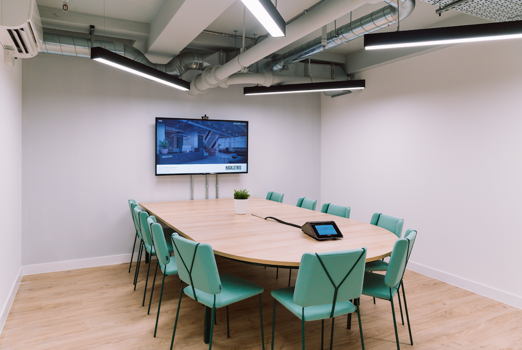 Modern Plex Meeting Room with oval table and mint-green chairs for collaborative sessions.
