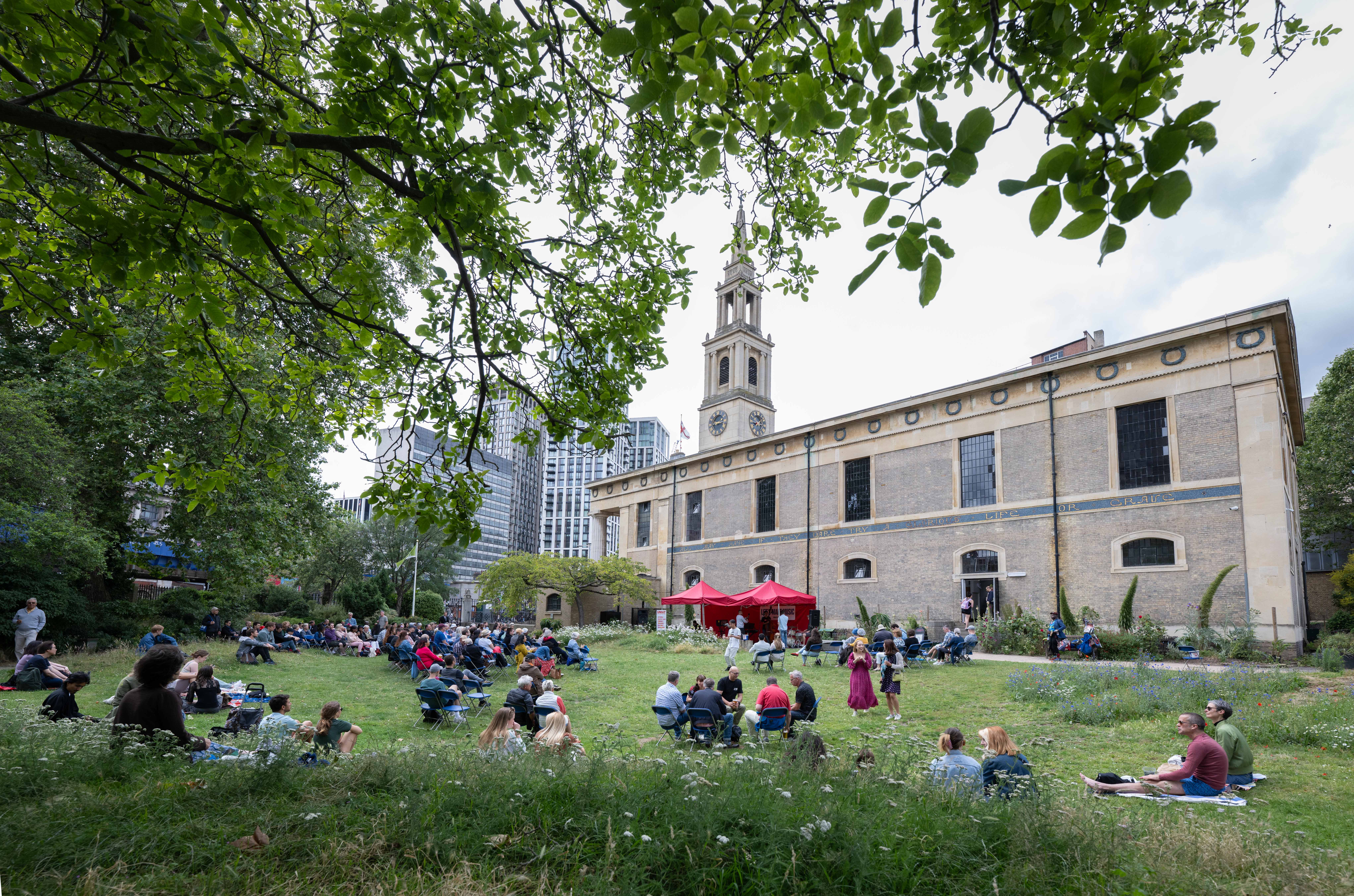 Vibrant outdoor event at St John's Church Waterloo, featuring lush greenery and historic charm.