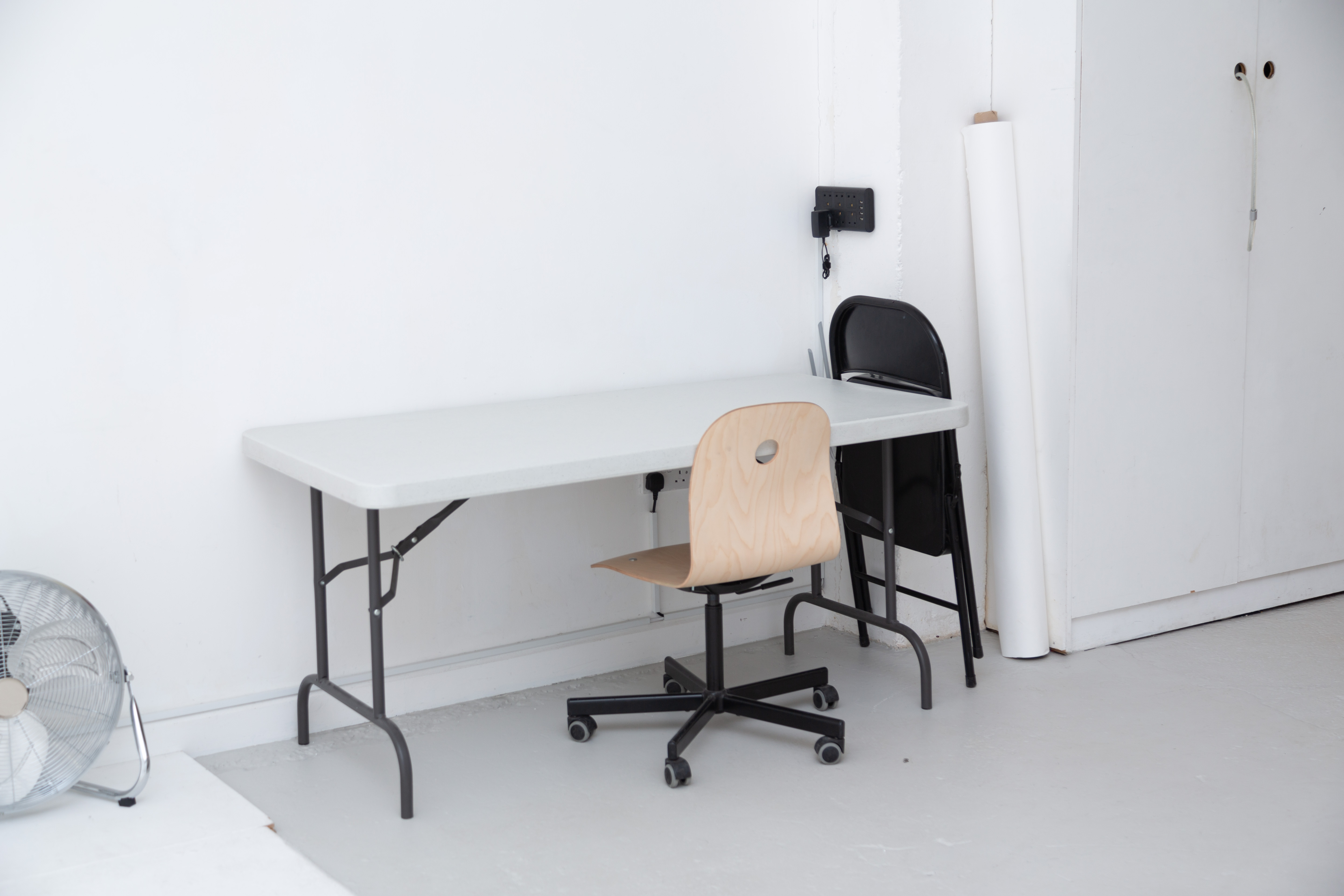 Minimalist Cove Studio setup with folding table and chairs for events and meetings.