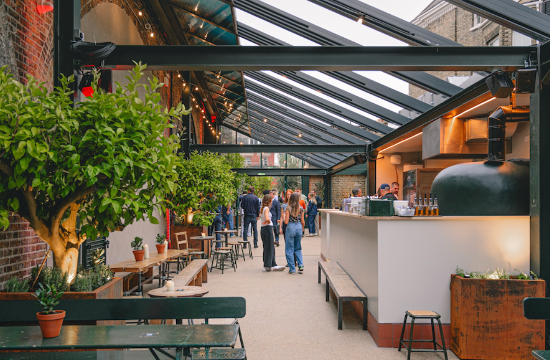 Vibrant open-air venue with glass roof, ideal for events and receptions.