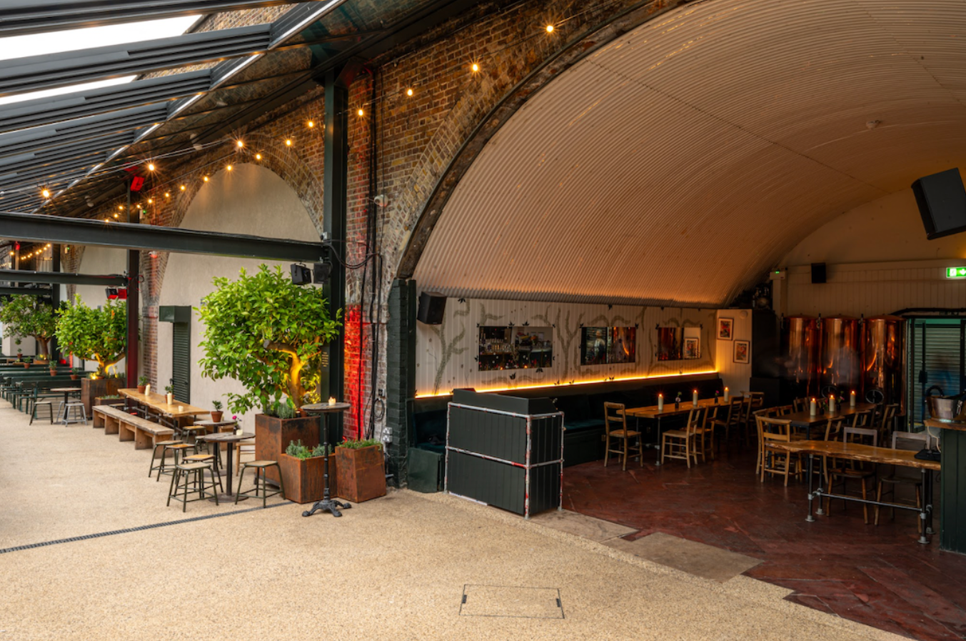 Versatile event space with warm lighting and greenery for gatherings and meetings.