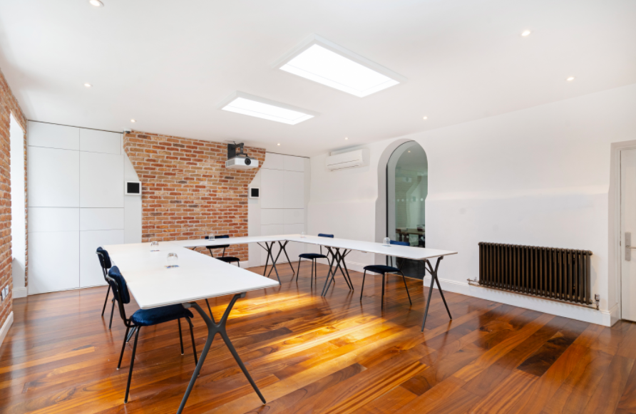 Modern meeting room with exposed brick, ideal for workshops and presentations.