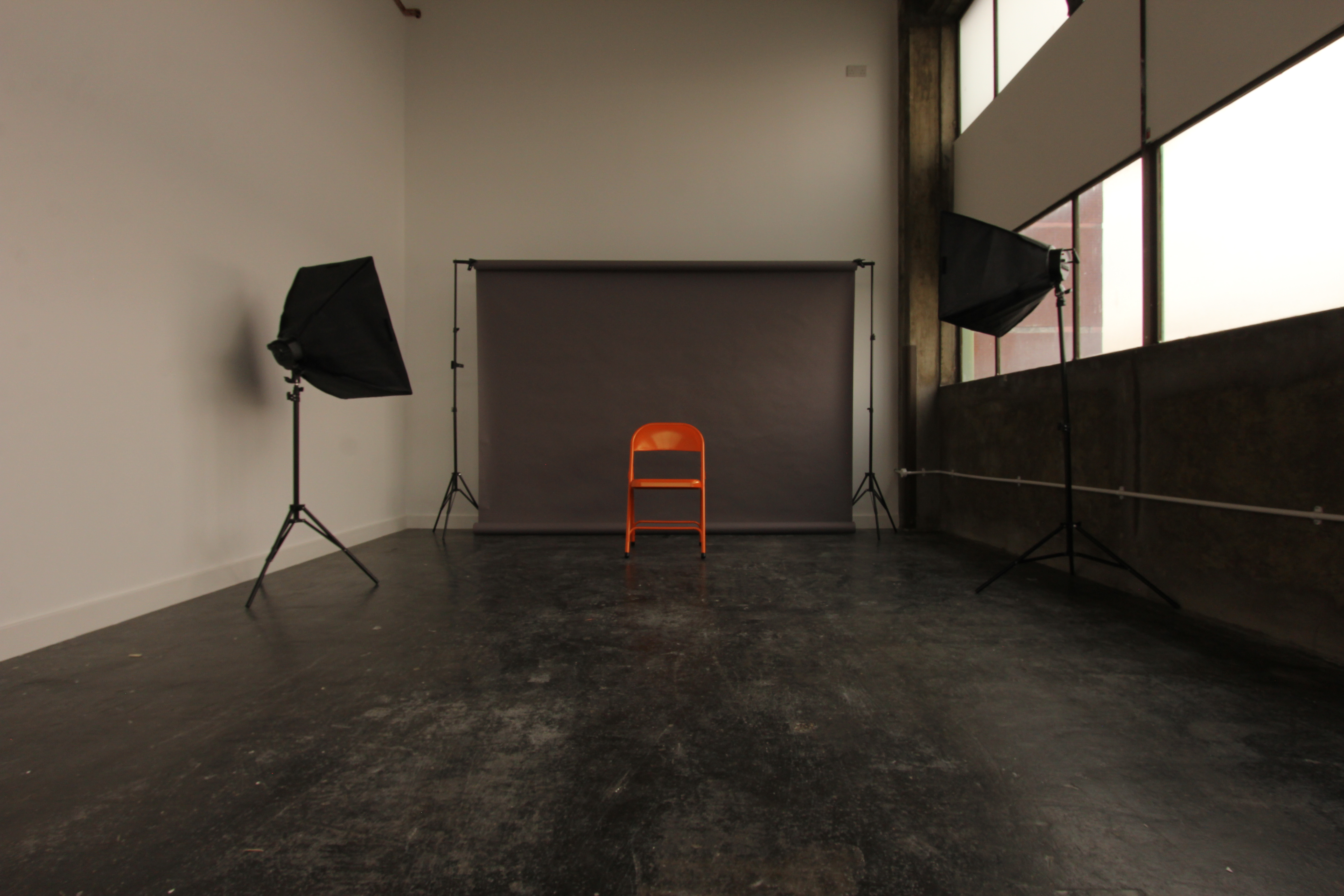 Minimalist meeting venue with orange chair, ideal for interviews and workshops.