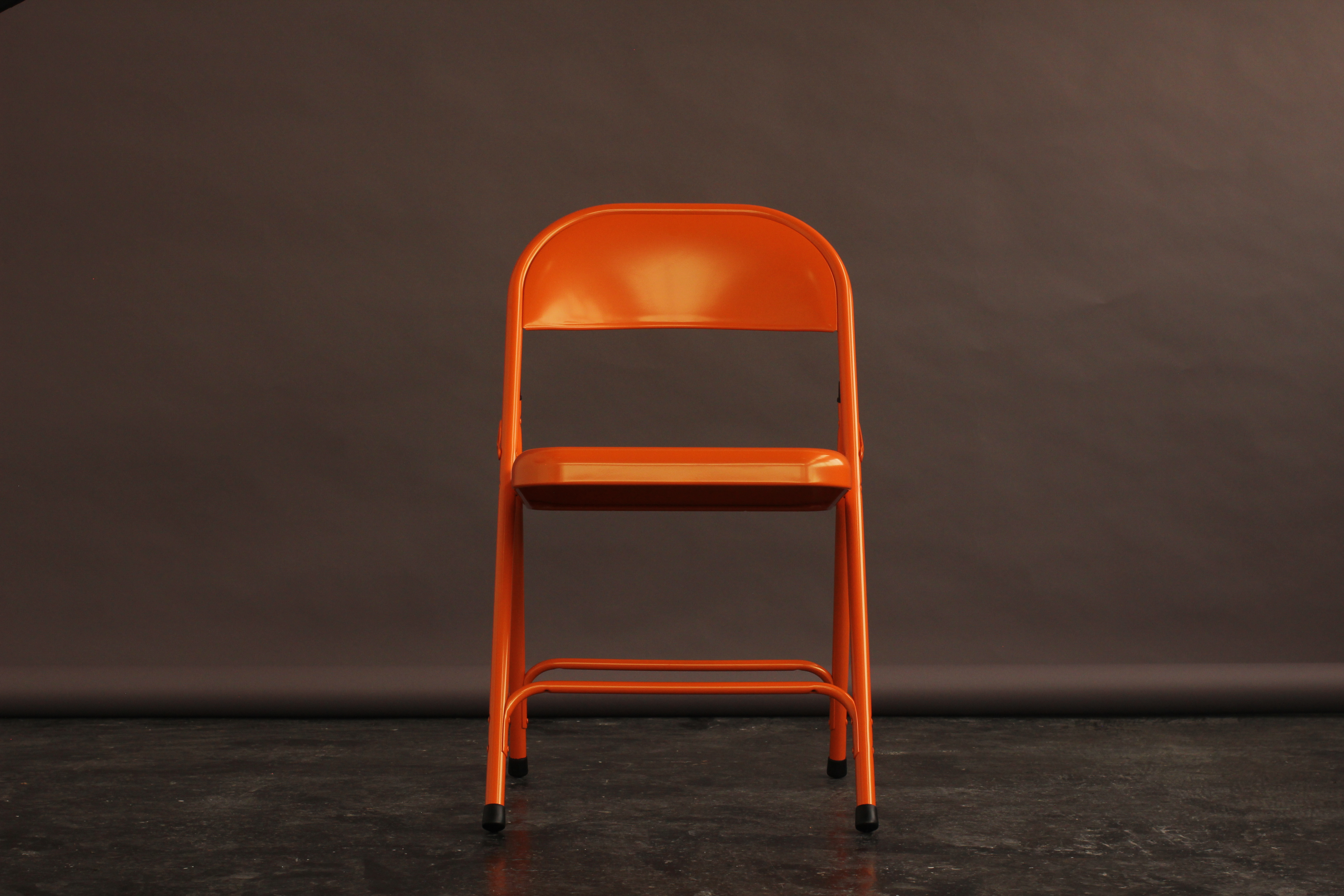 Vibrant orange chair in Aseptic Studios for modern meetings and creative workshops.