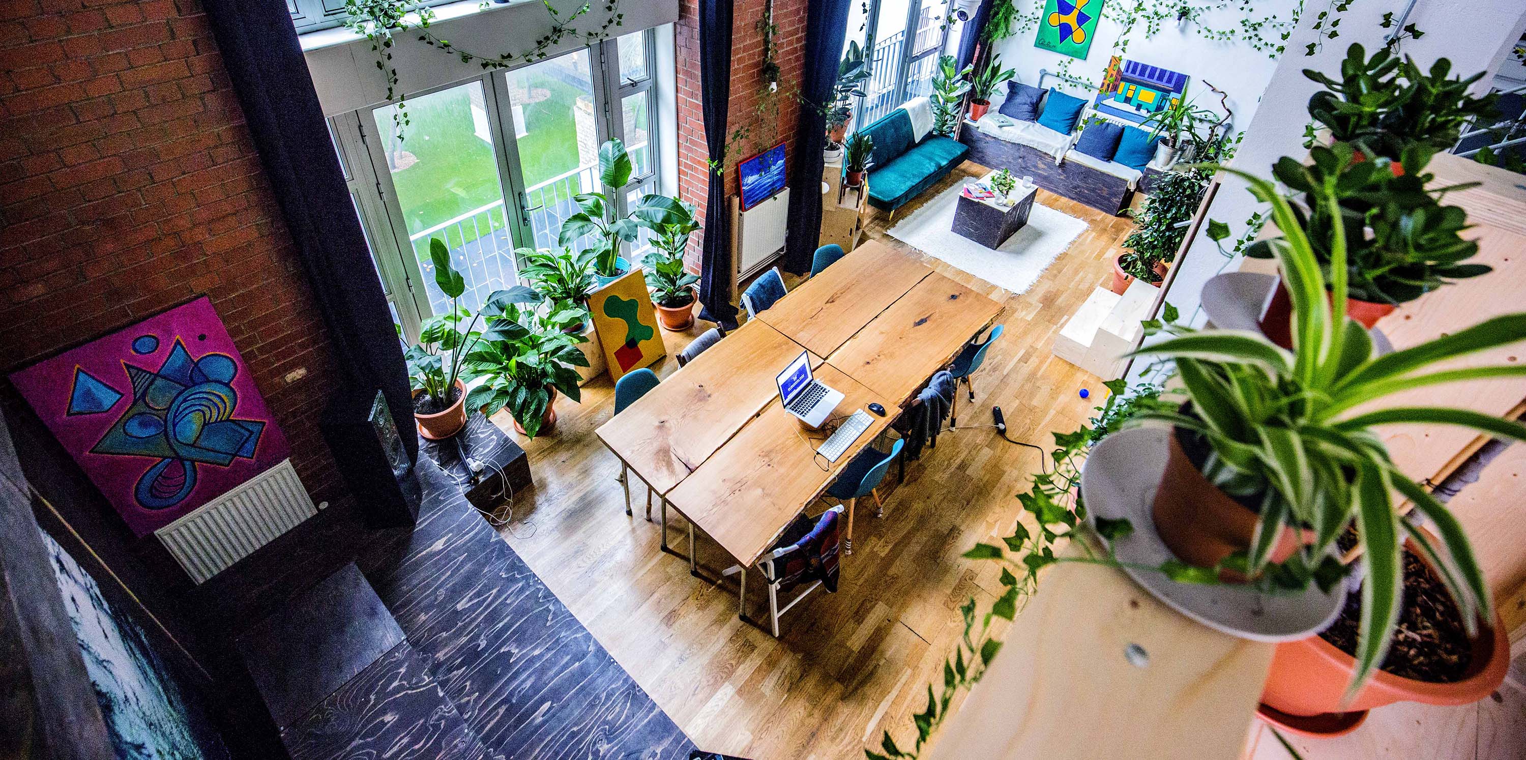 Vibrant meeting space with wooden table and greenery for creative collaboration events.