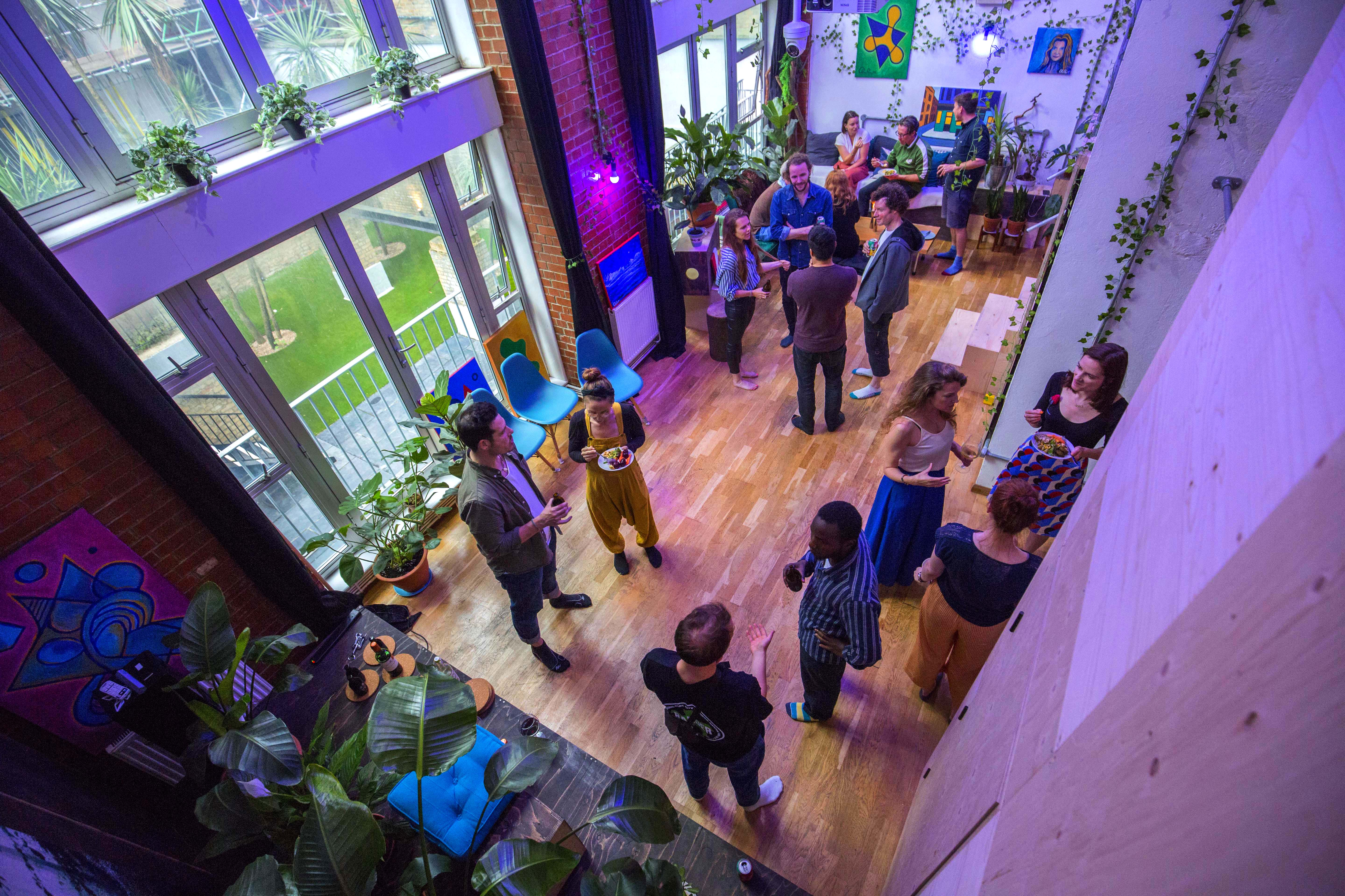 Vibrant networking event at House of Transformation with colorful decor and greenery.