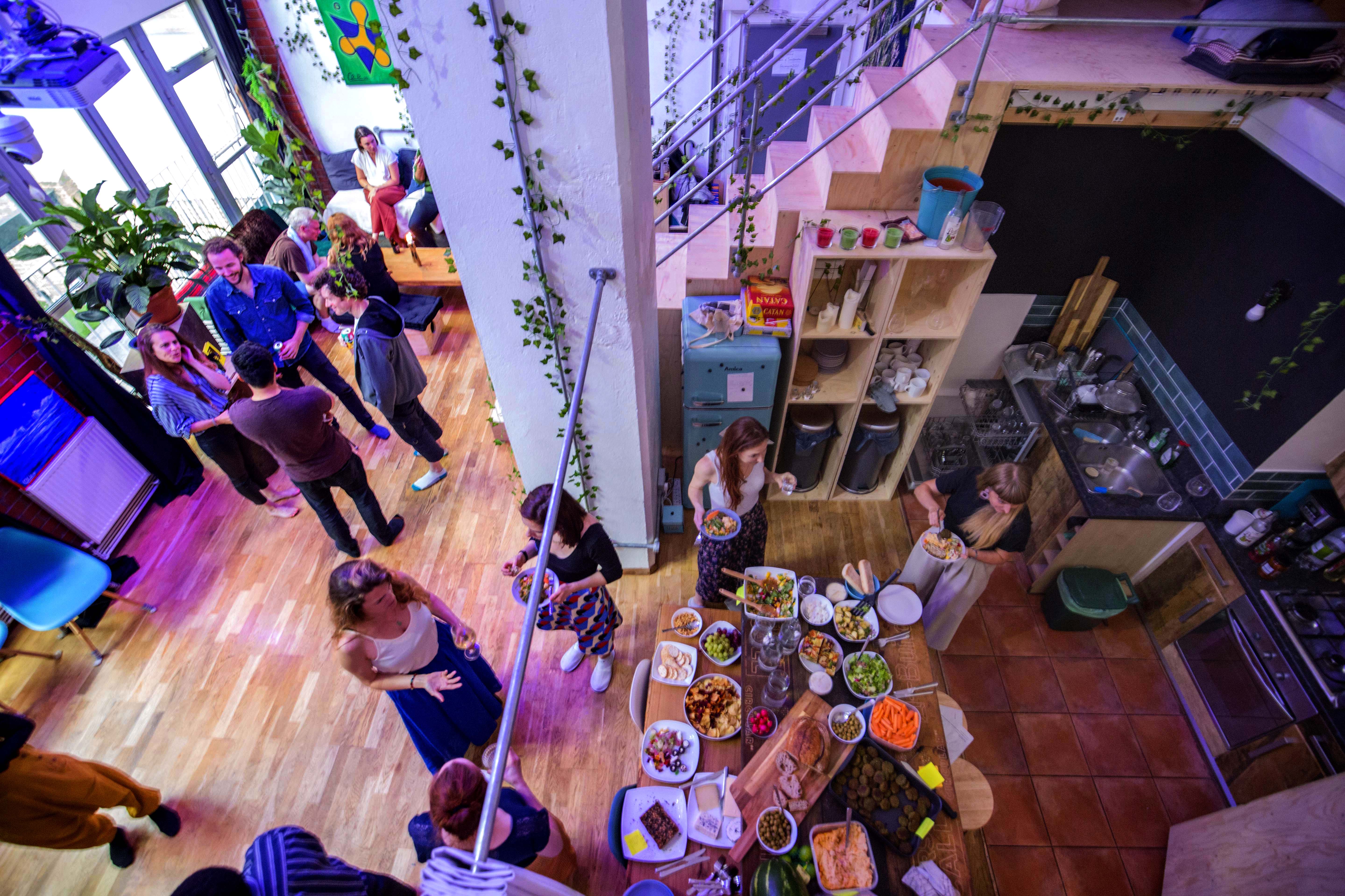 Vibrant networking event at House of Transformation with buffet and greenery.