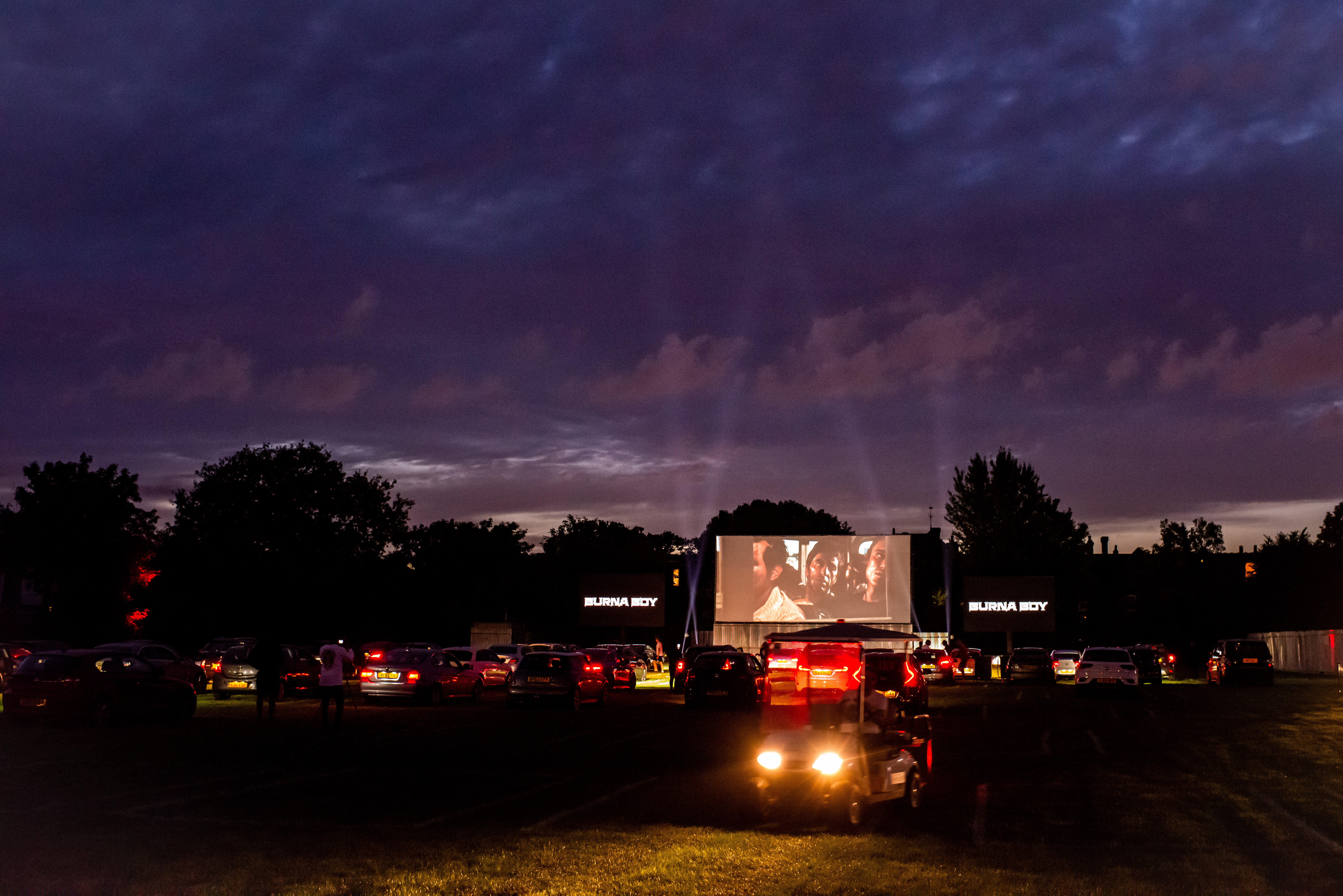 Drive-in movie setup at Sunset Cinema with large screen for outdoor events.