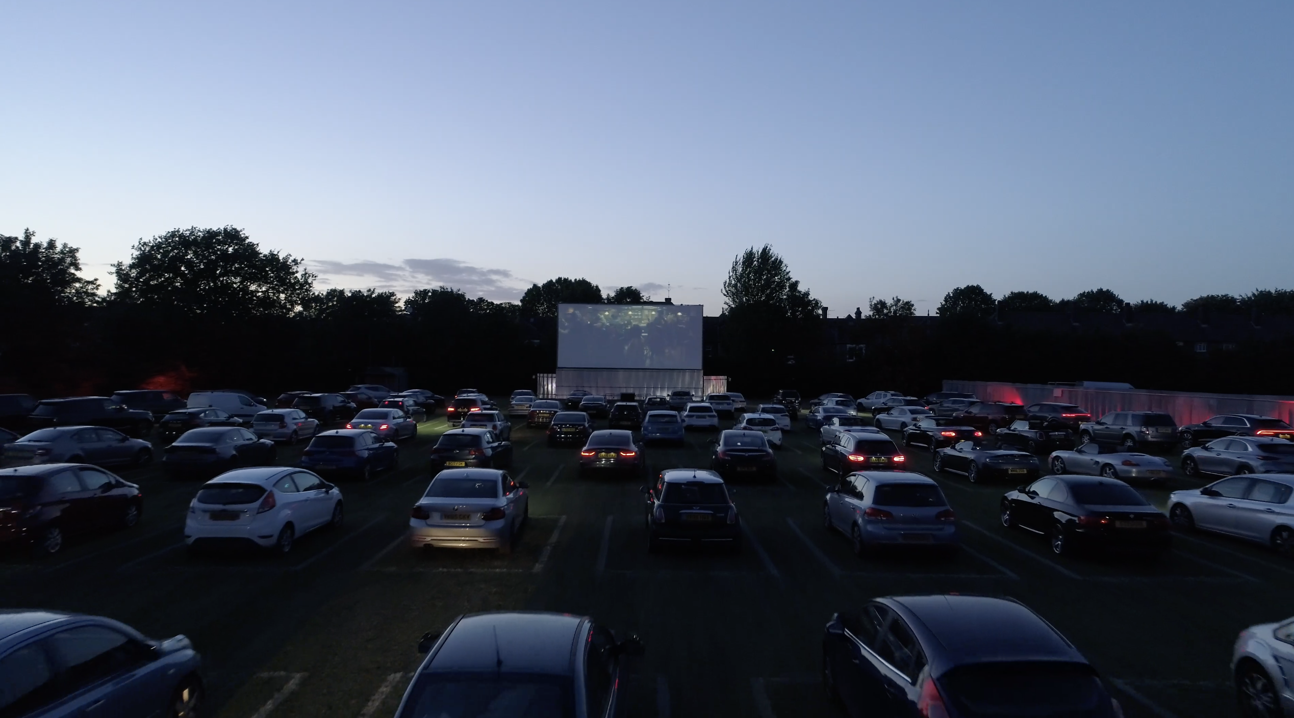 Drive-in movie setup at Sunset Cinema with large screen for outdoor events.