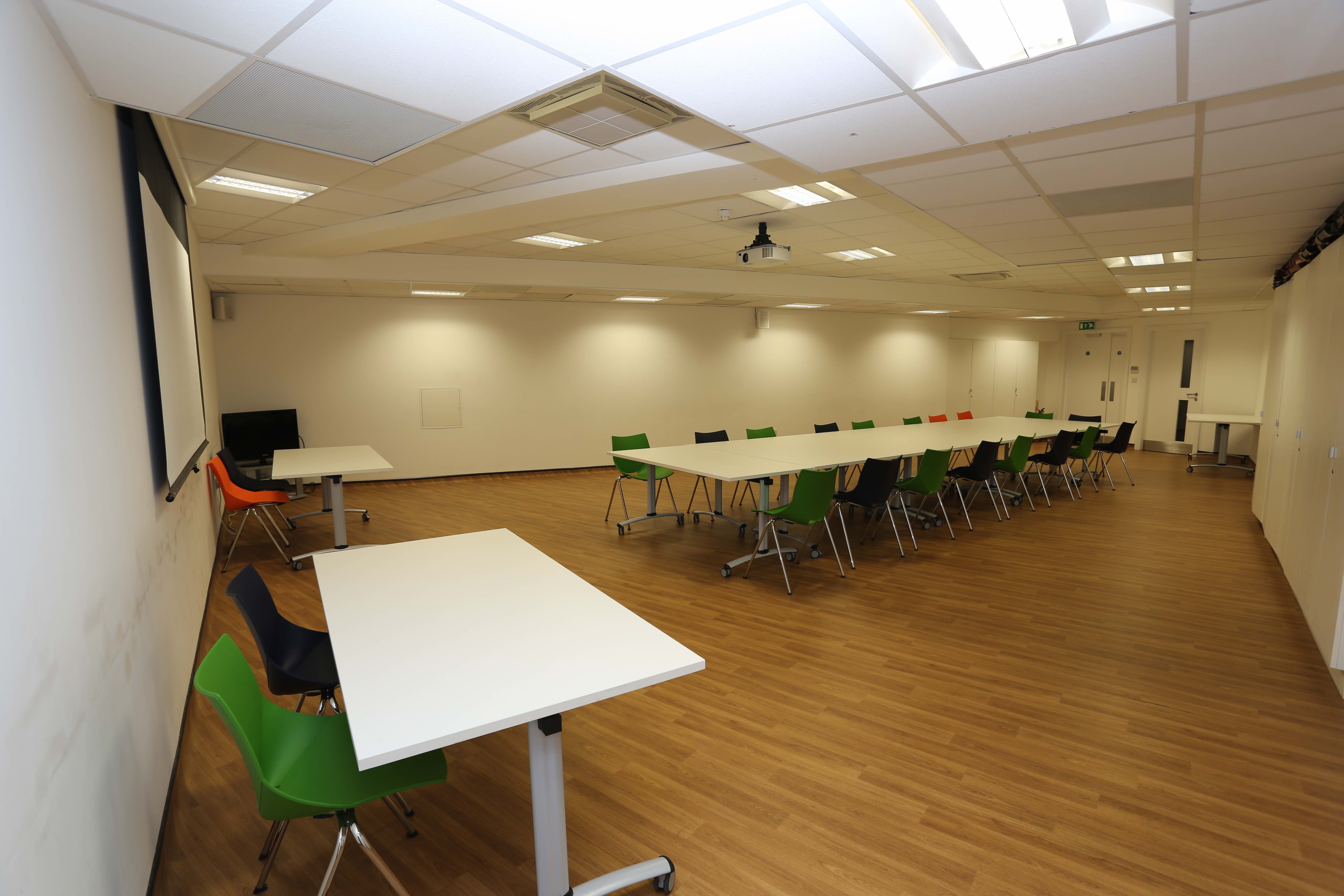 Main hall in Chinese Community Centre with colorful chairs, perfect for workshops and meetings.