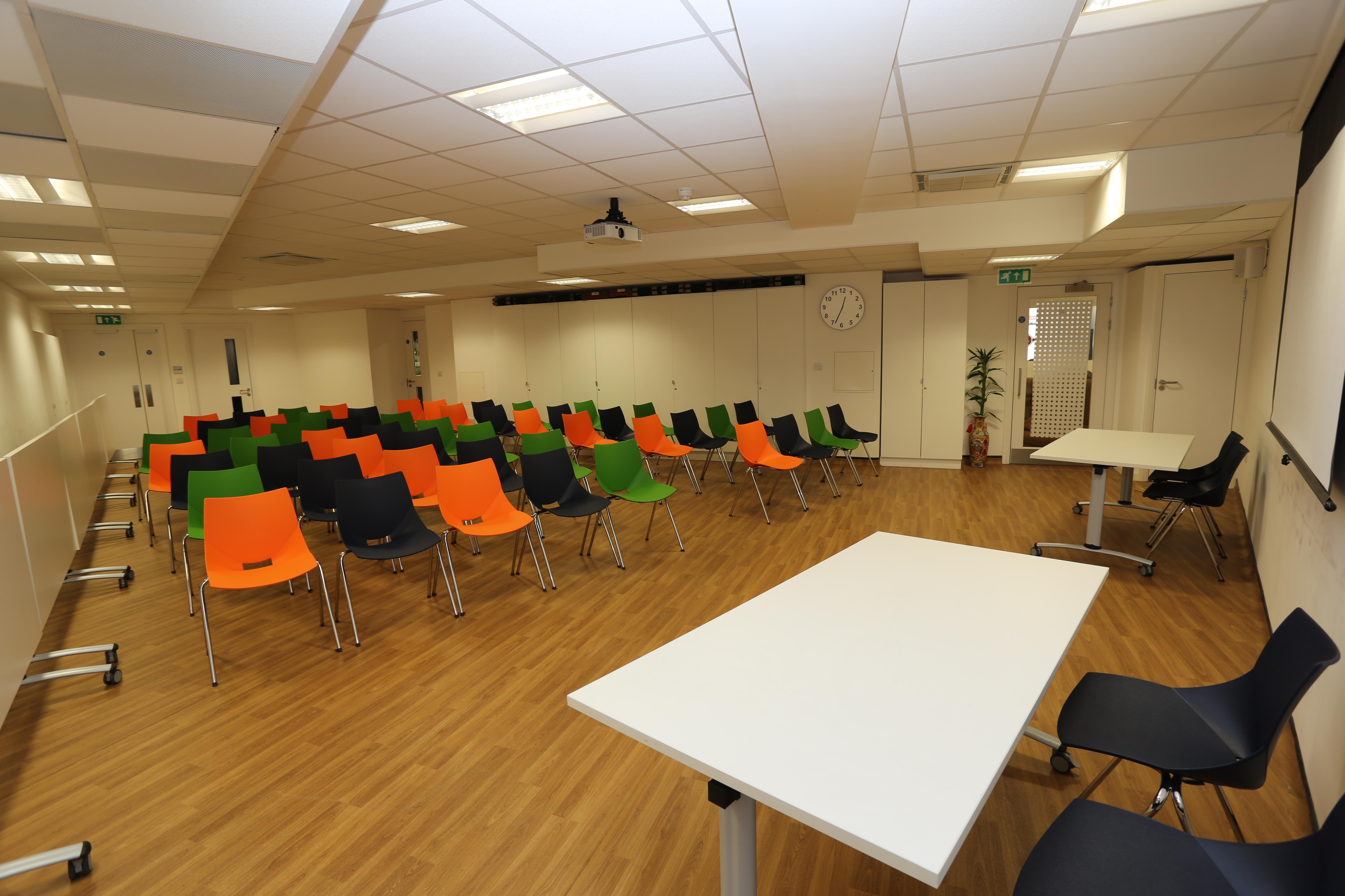 Main hall in Chinese Community Centre with colorful chairs for workshops and presentations.