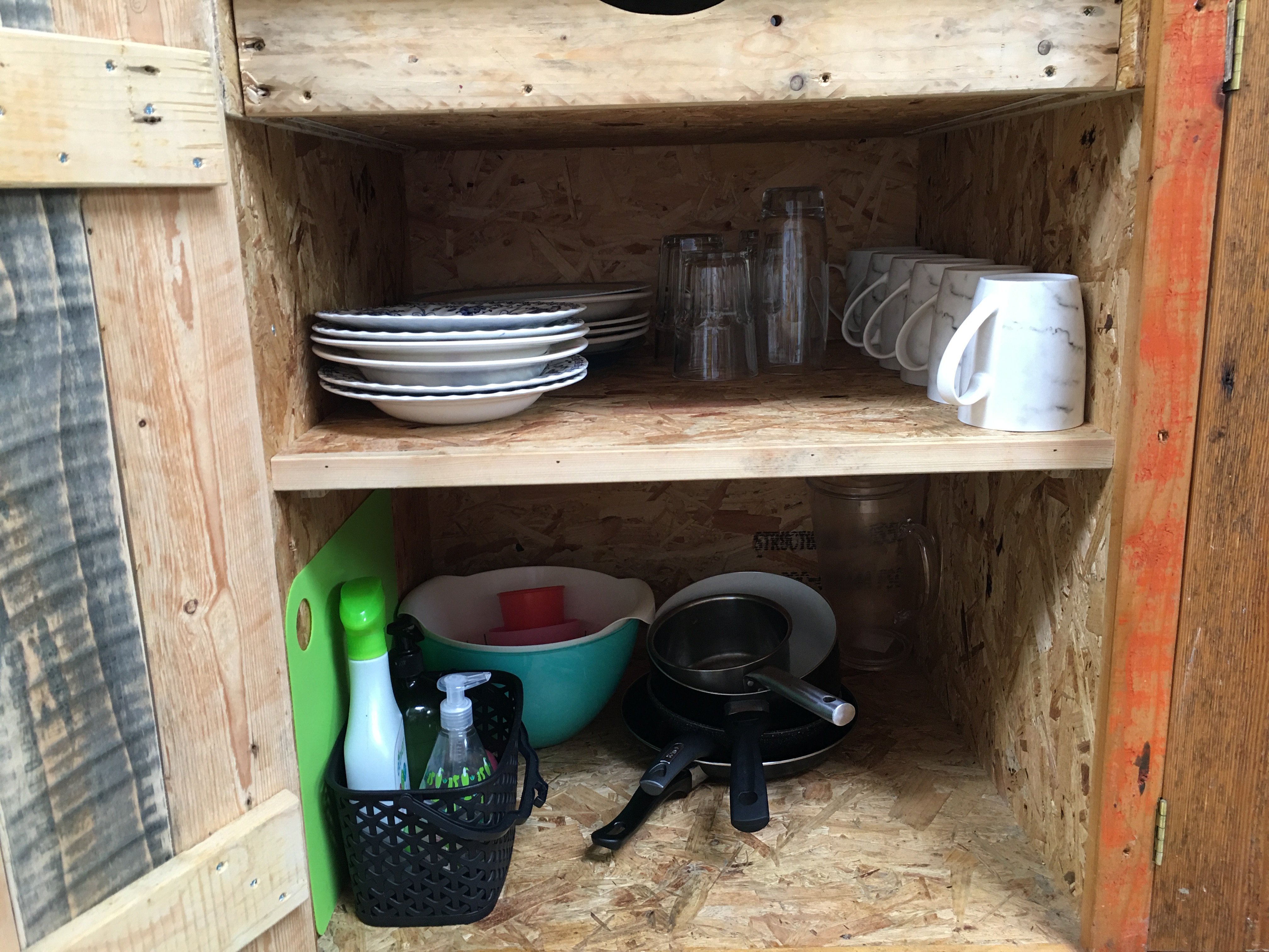 Koa tree event supply storage with plates and utensils for efficient catering setup.