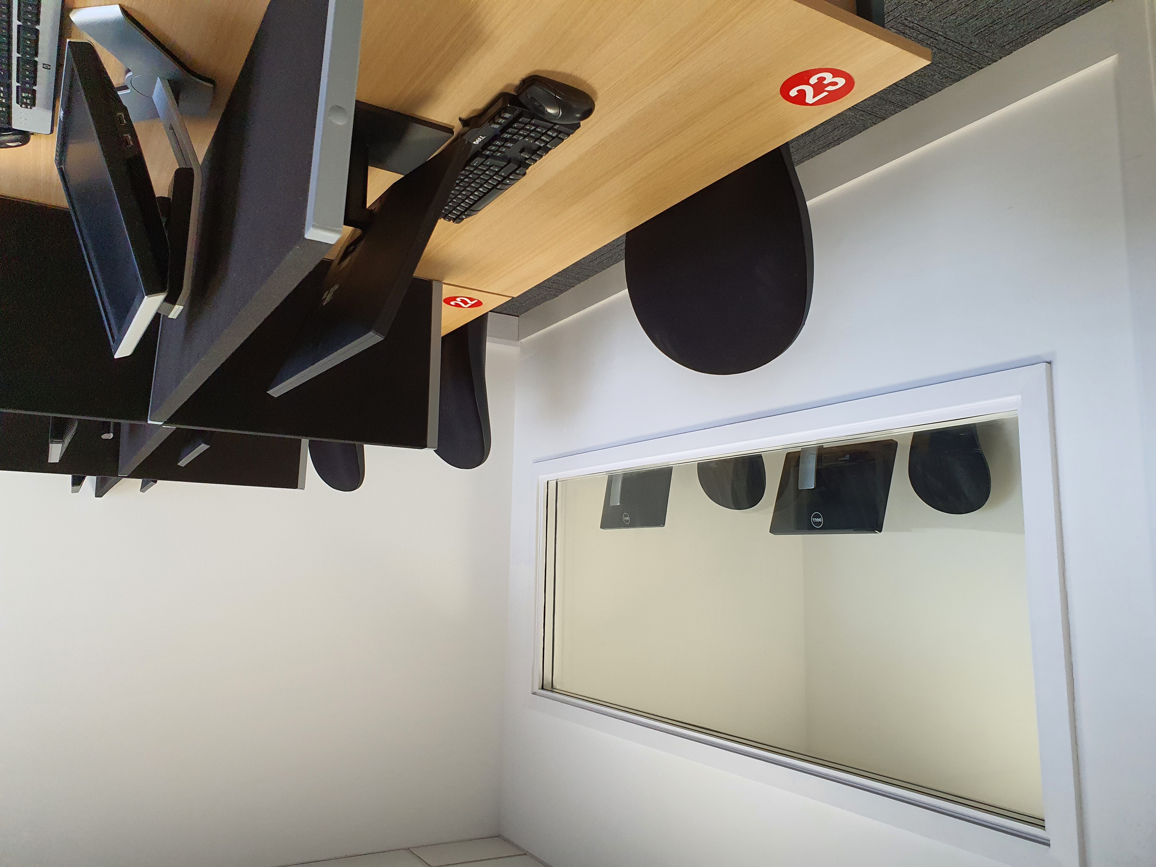 Modern training room with computers and glass observation area for workshops.