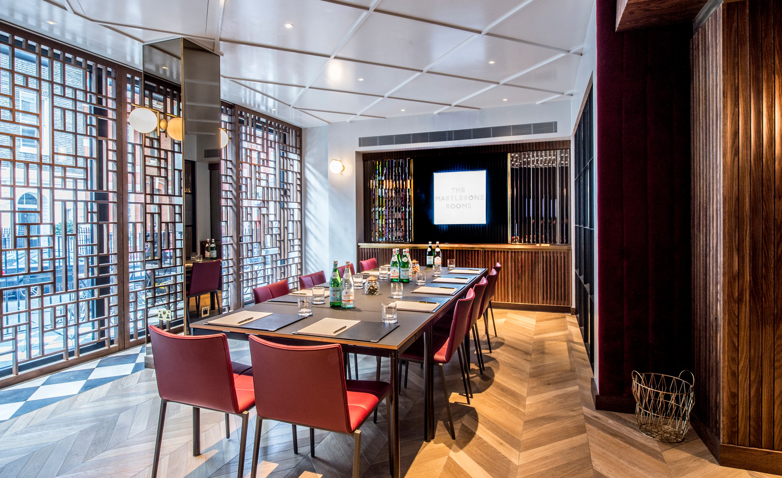 Modern meeting room at The Marylebone with a sleek wooden table for professional gatherings.