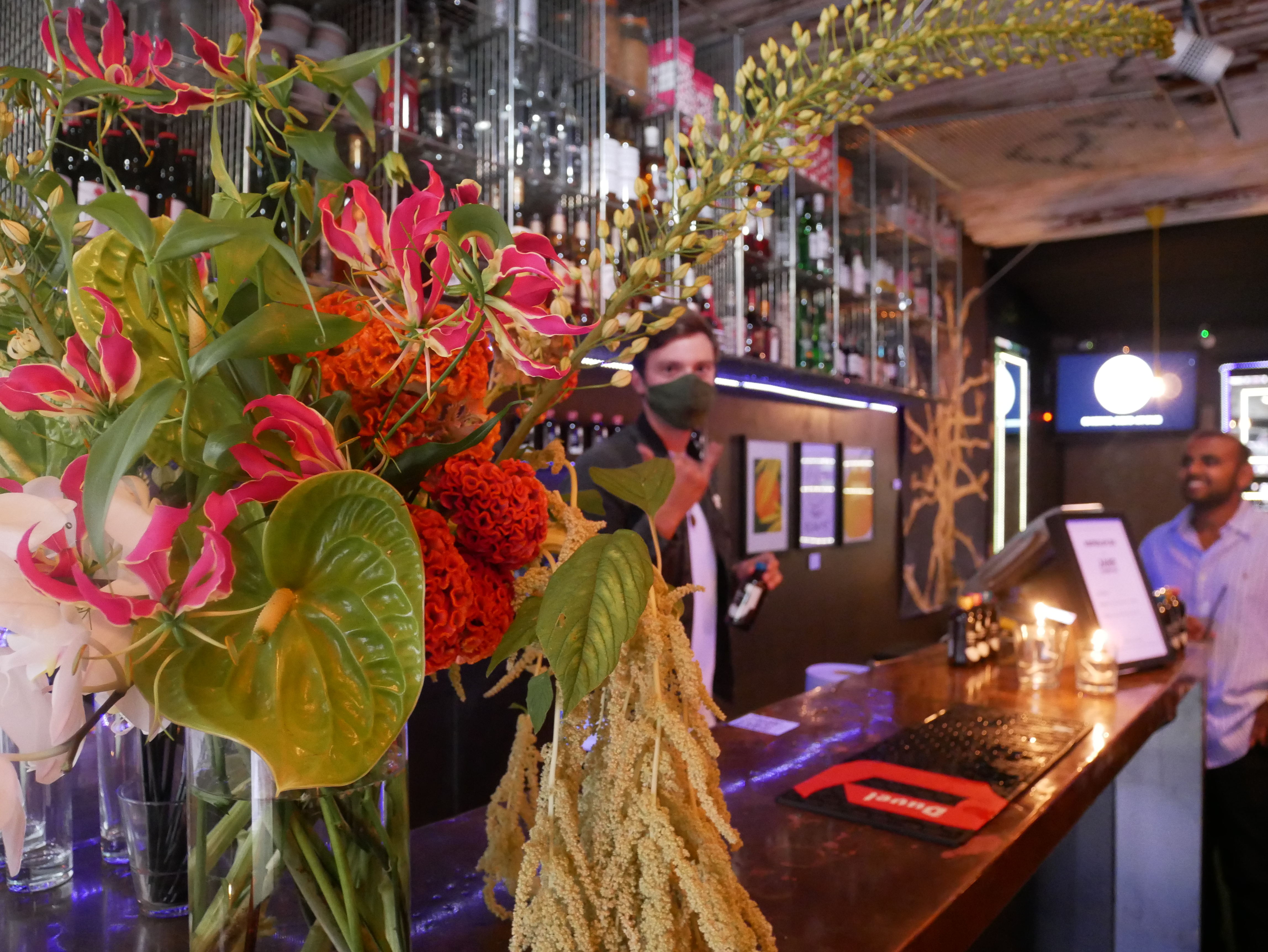 Vibrant bar venue in Sugarlandia with lush floral decor for networking events.