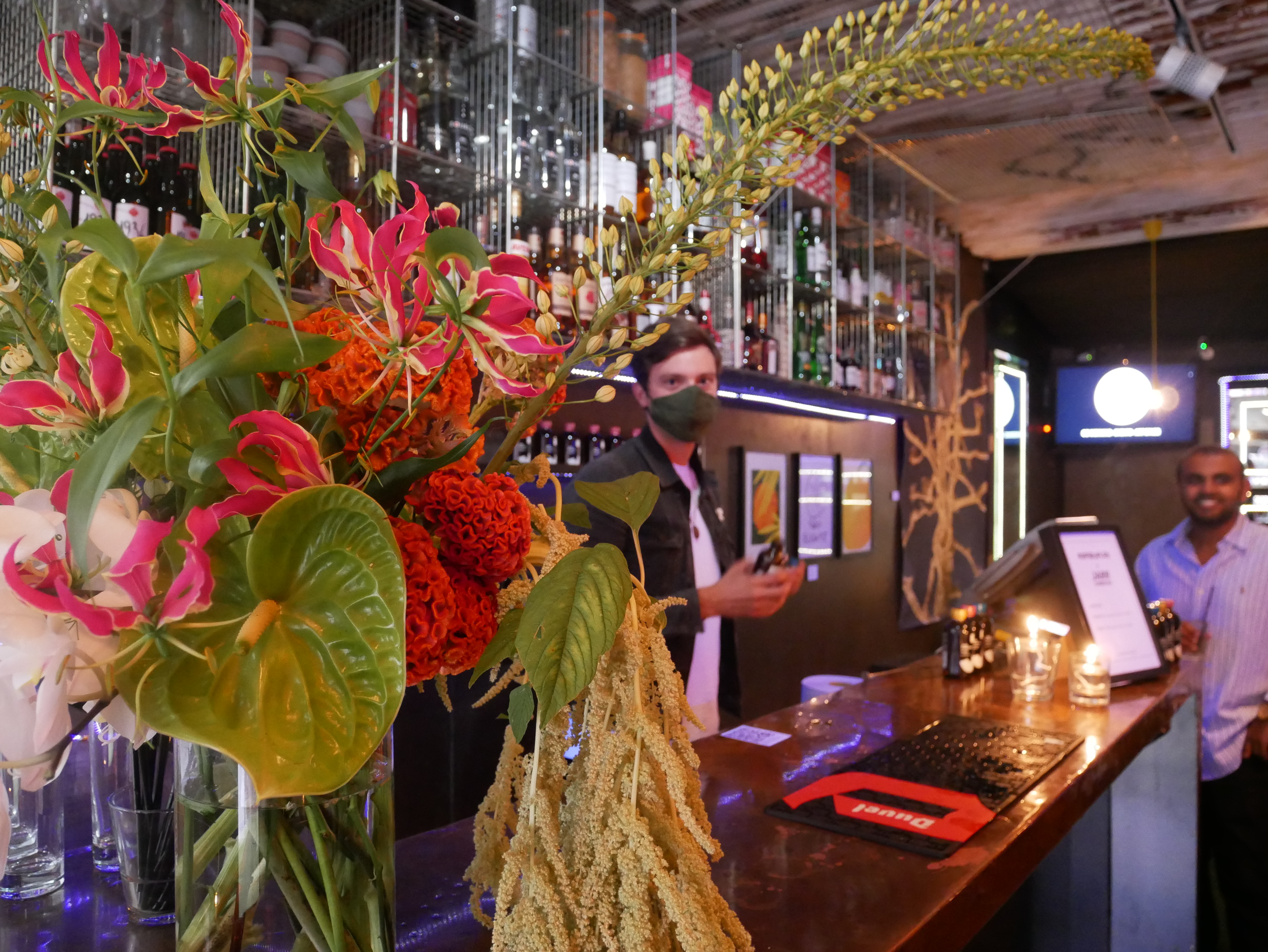 Vibrant bar setup with floral decor at Sugarlandia venue for events and gatherings.