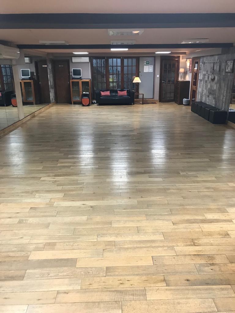 Spacious event venue with polished wooden floors for meetings and workshops.