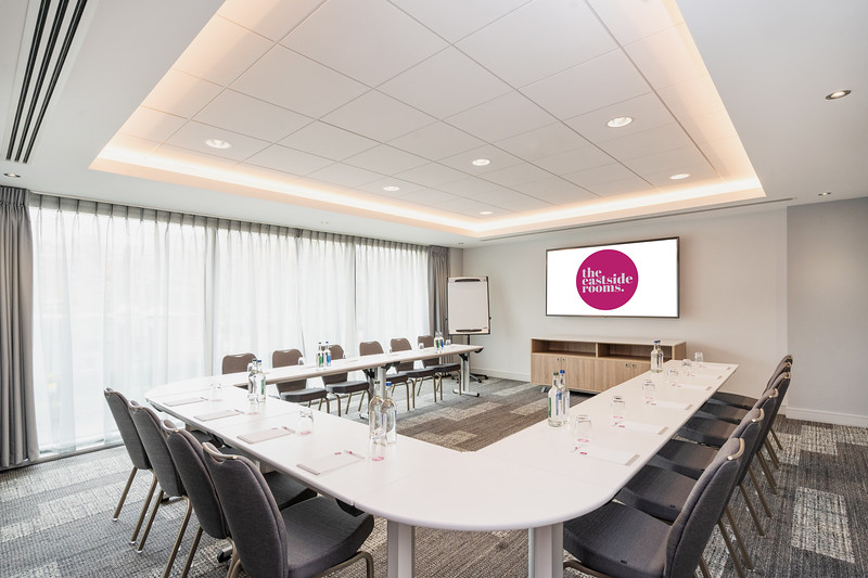 Modern meeting room with U-shaped table, ideal for workshops and presentations.