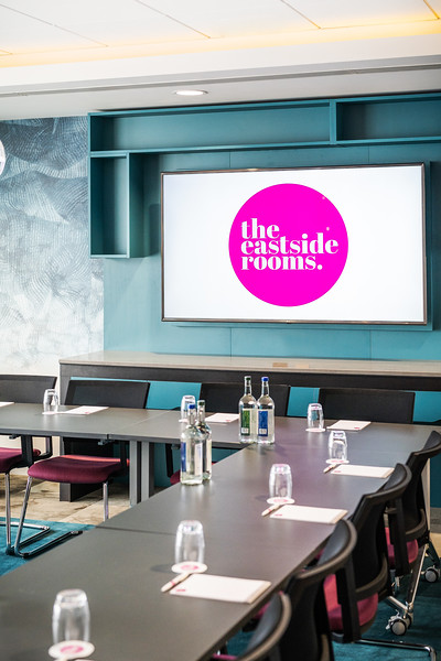 Modern meeting room at The Eastside Rooms with sleek table setup and vibrant branding.
