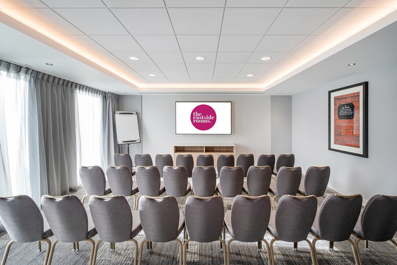 Meeting Room Seven setup for corporate presentations with elegant chairs and large screen.