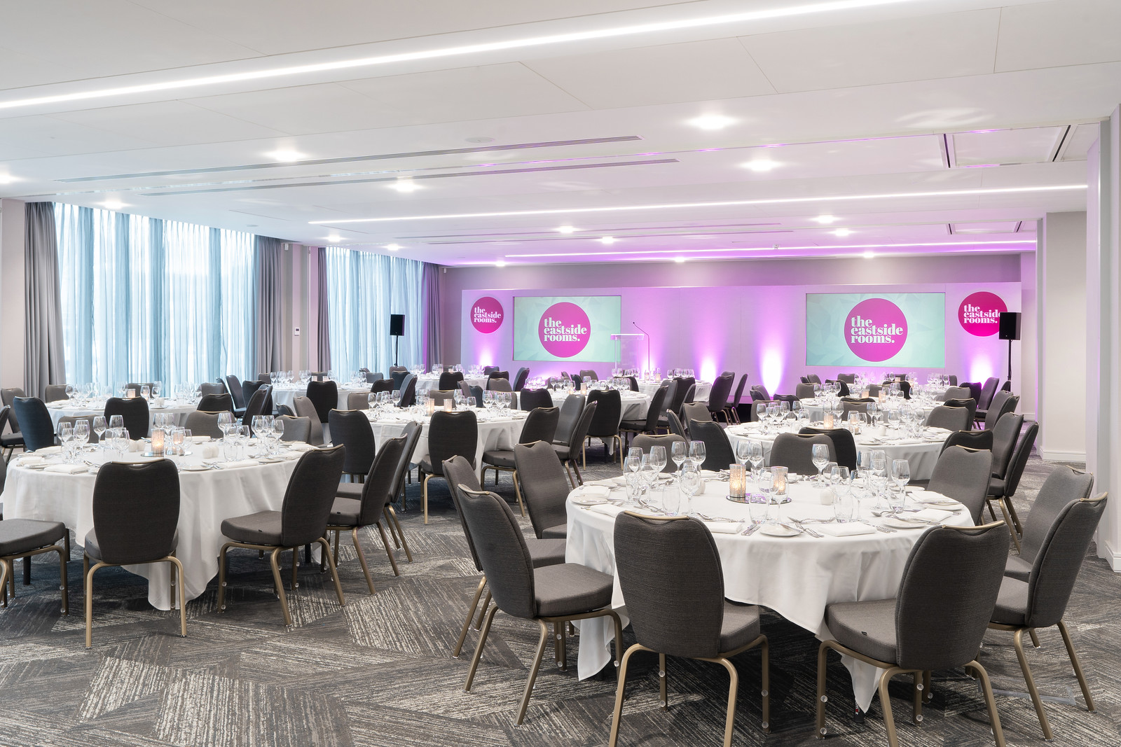 Ashtead Suite event space with elegant round tables for corporate gatherings.