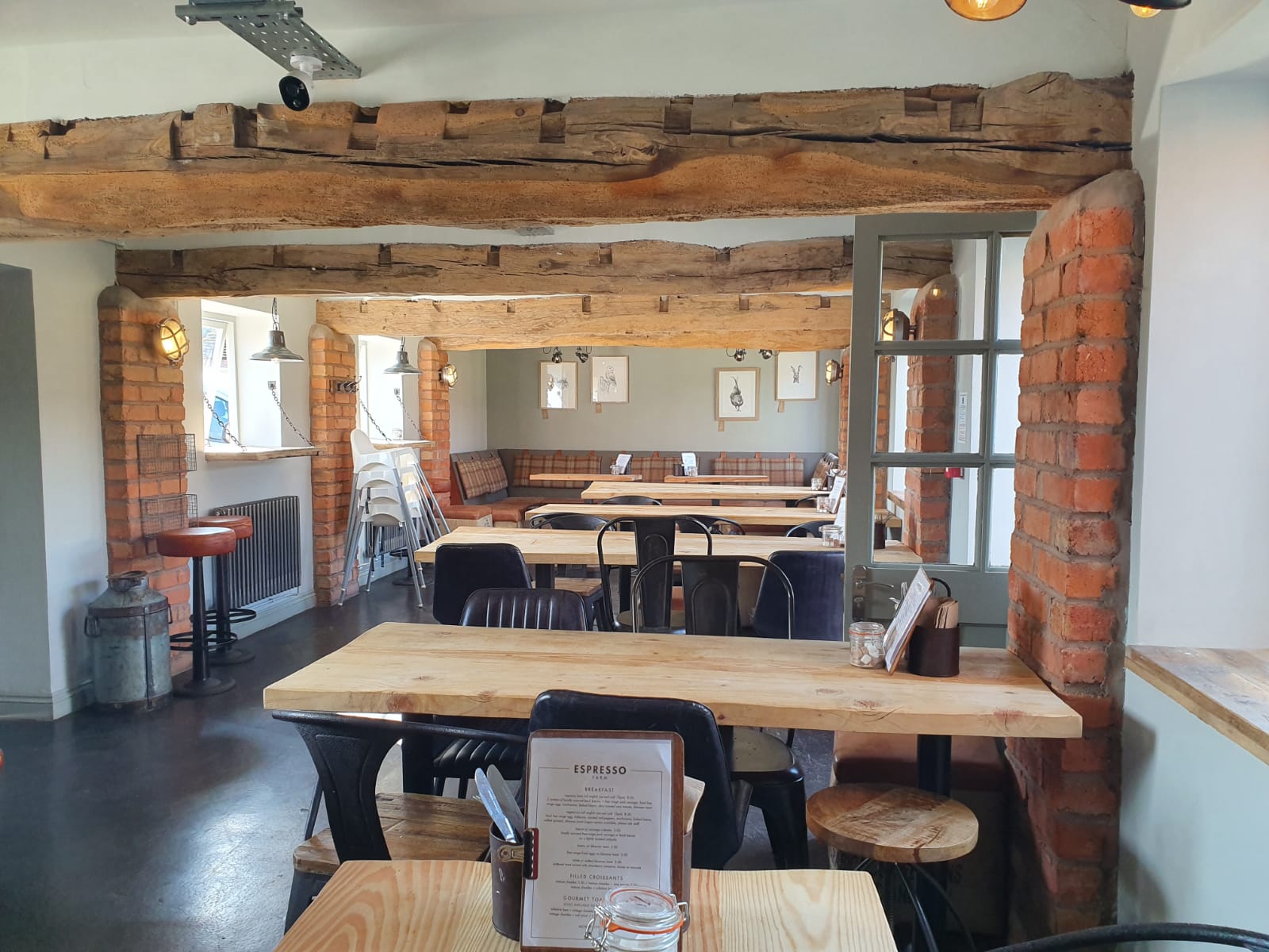 Versatile event space with rustic wooden beams, ideal for workshops and meetings.
