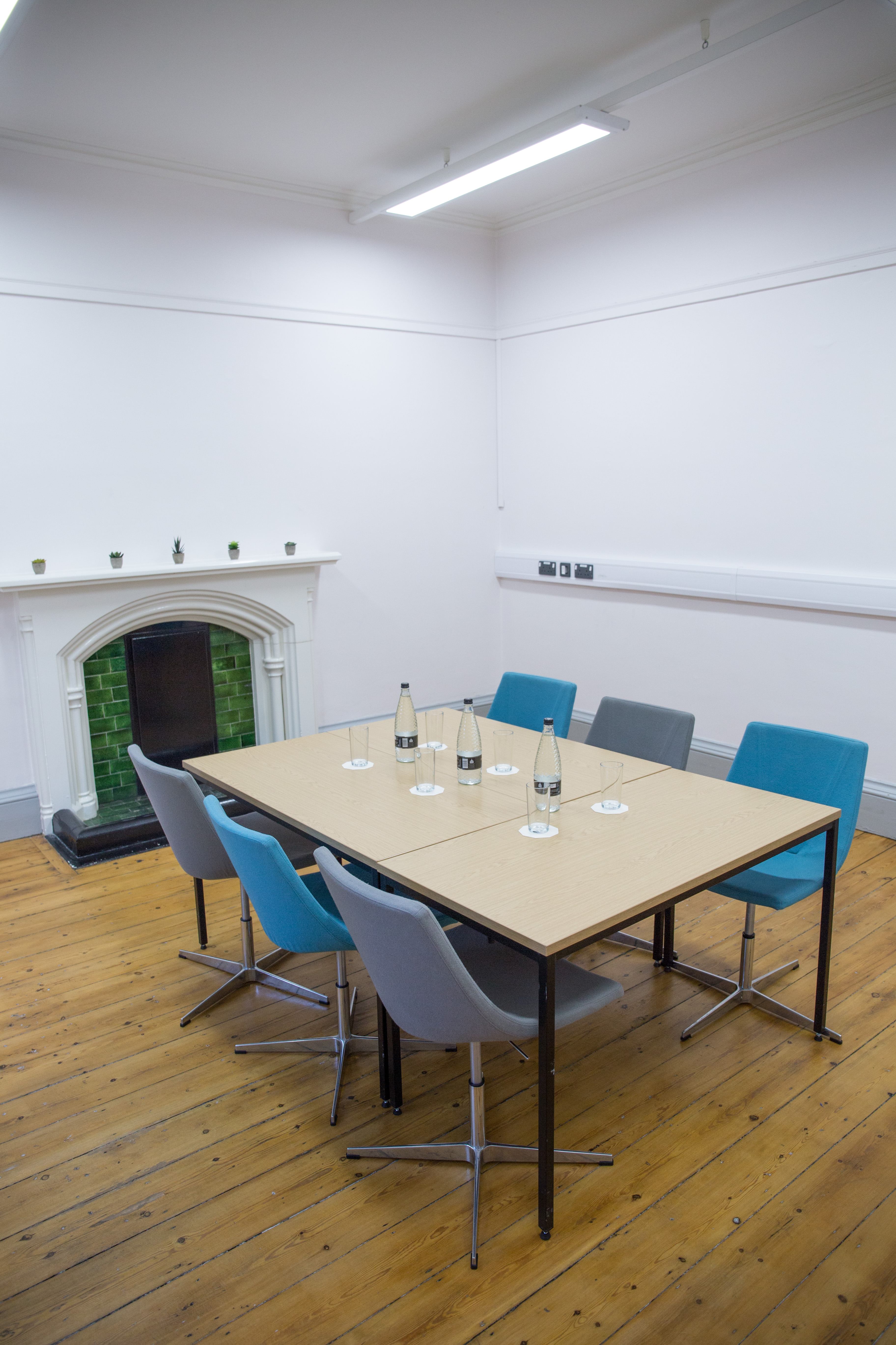 Modern meeting room at Chesterfield College with fireplace, ideal for productive discussions.