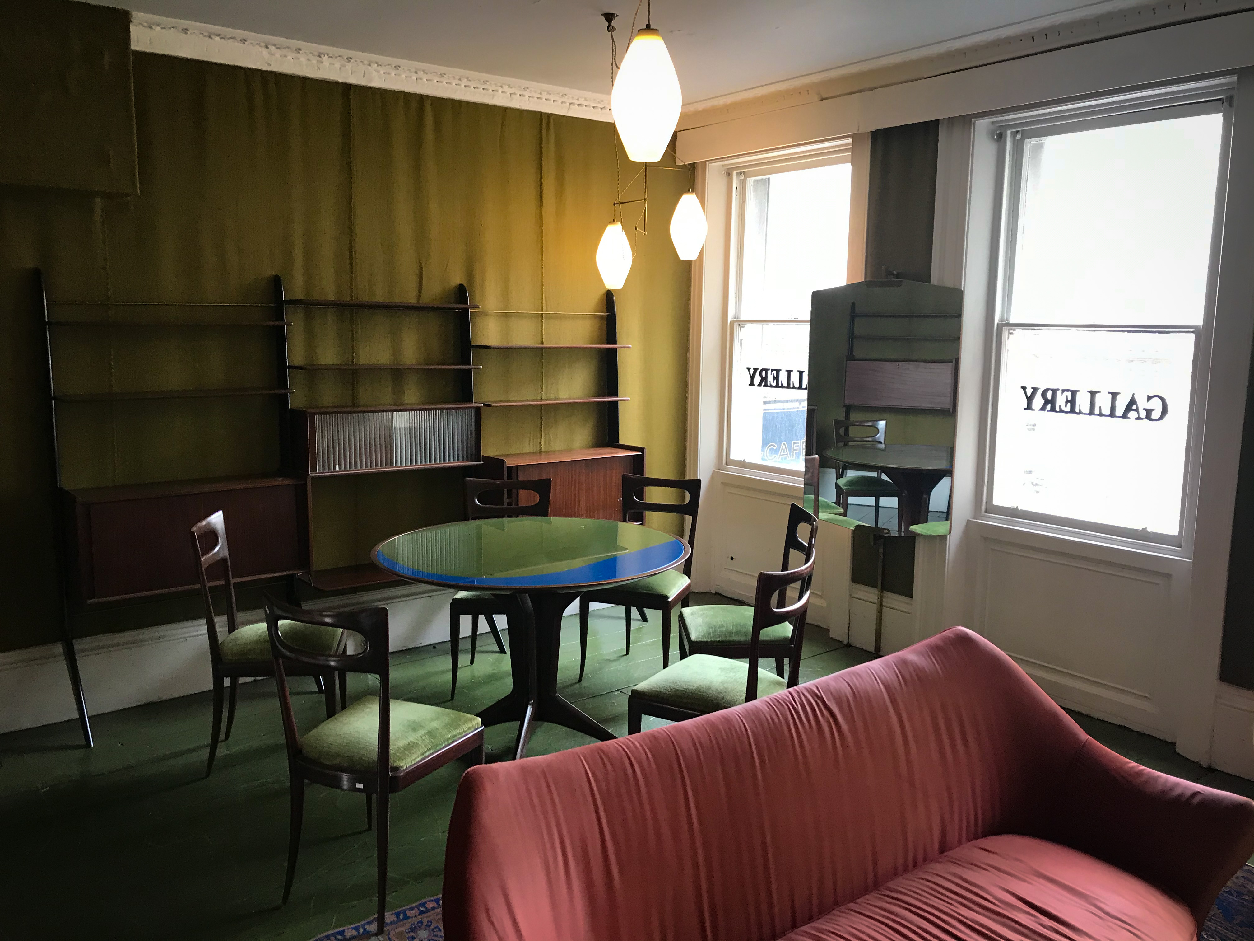 Stylish meeting space with round table and cozy sofa in Café Babka, perfect for gatherings.