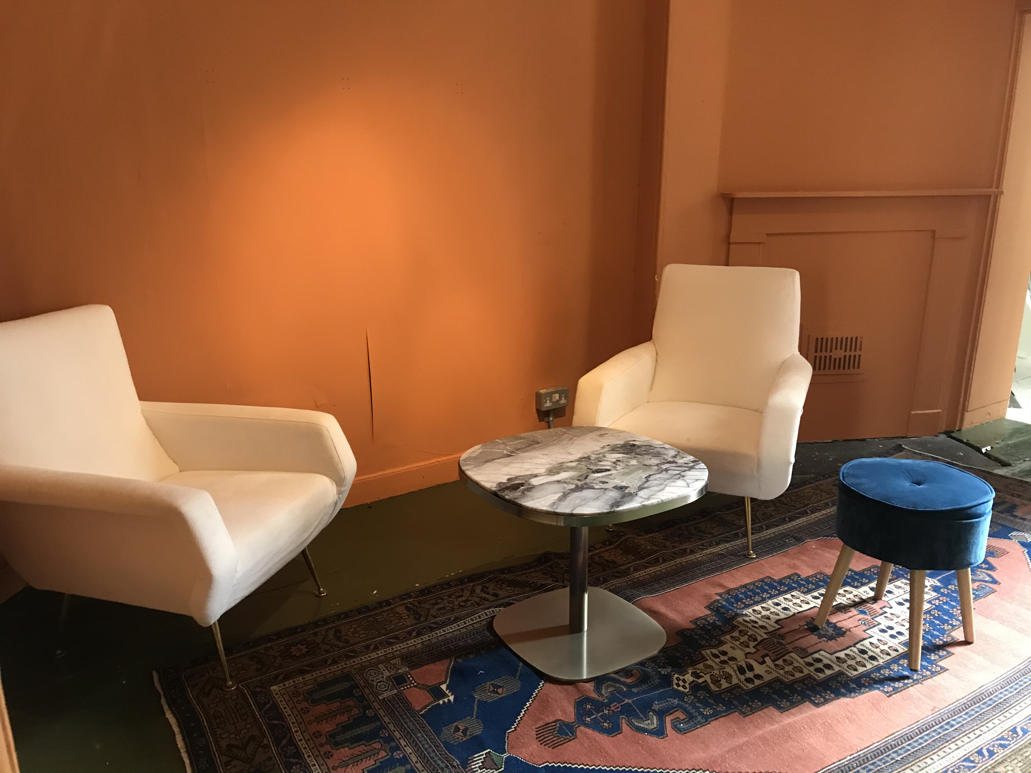Cozy meeting space in Café Babka with modern armchairs and marble table for brainstorming.