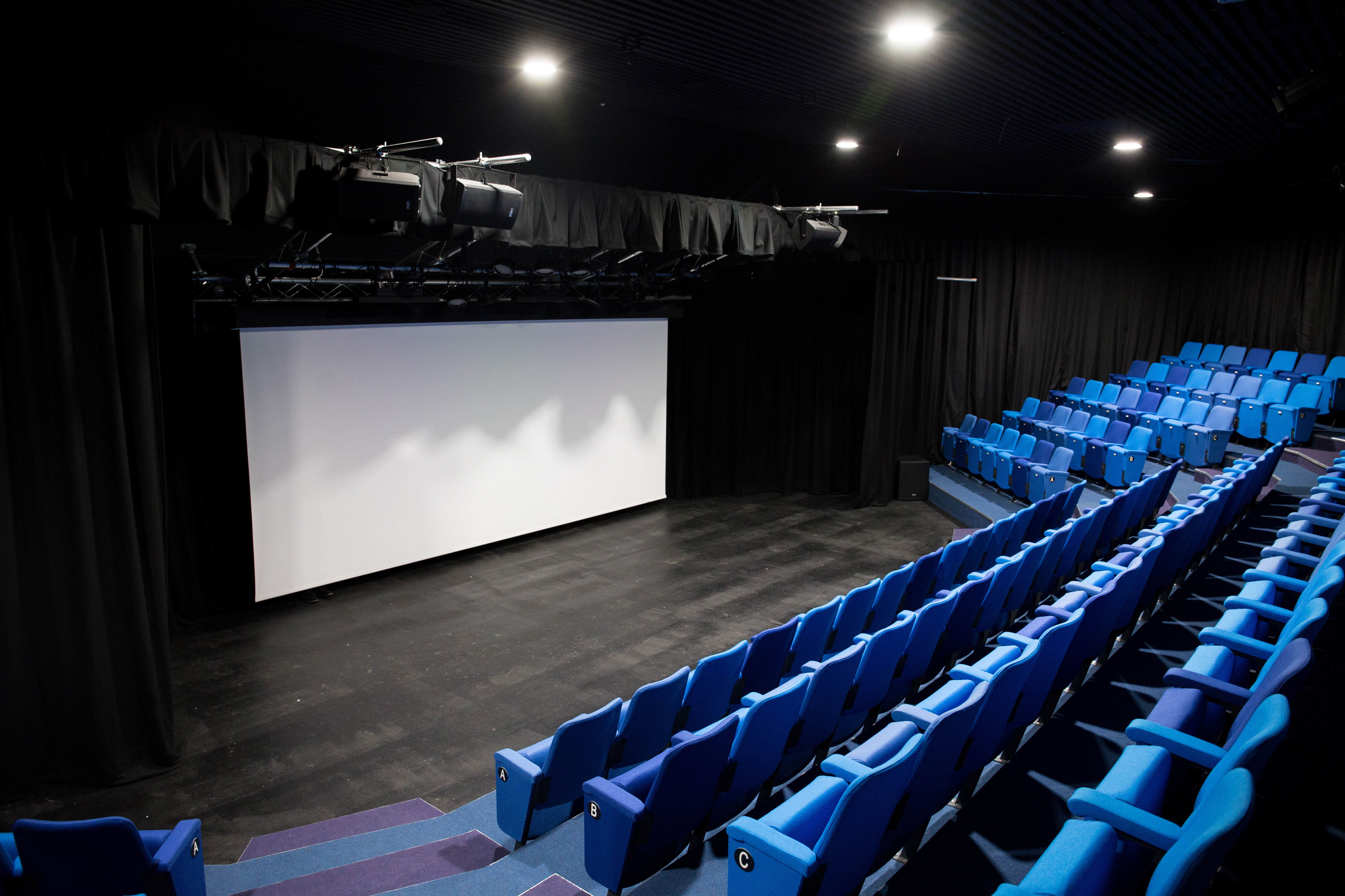 Chesterfield College theatre with tiered blue seating, ideal for presentations and performances.