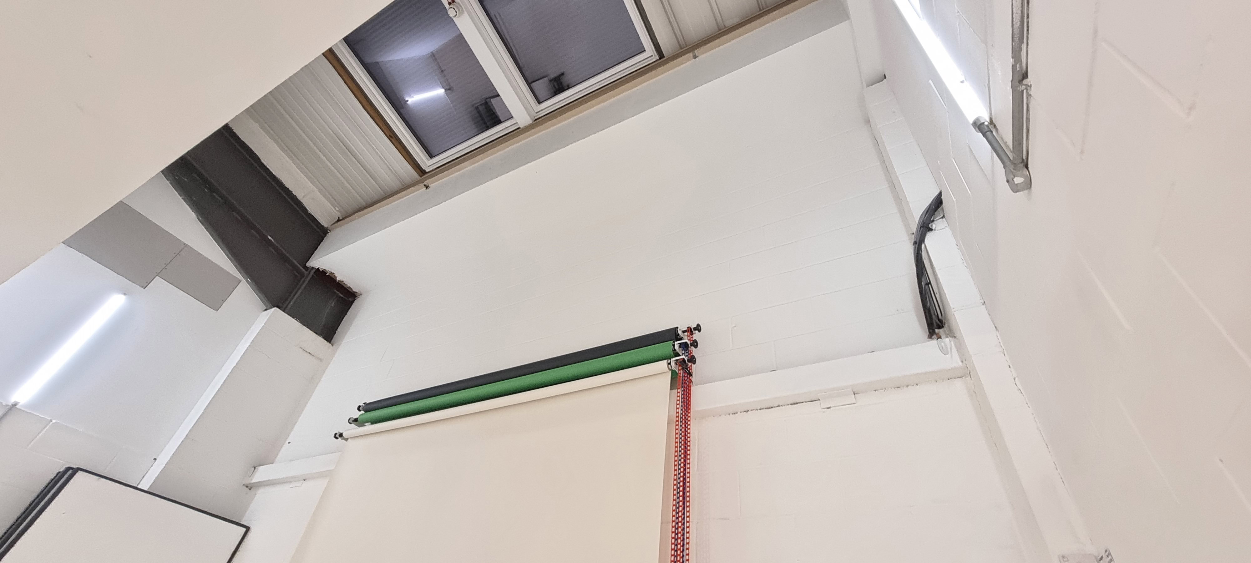 Minimalist photography studio with high ceiling, ideal for events and presentations.
