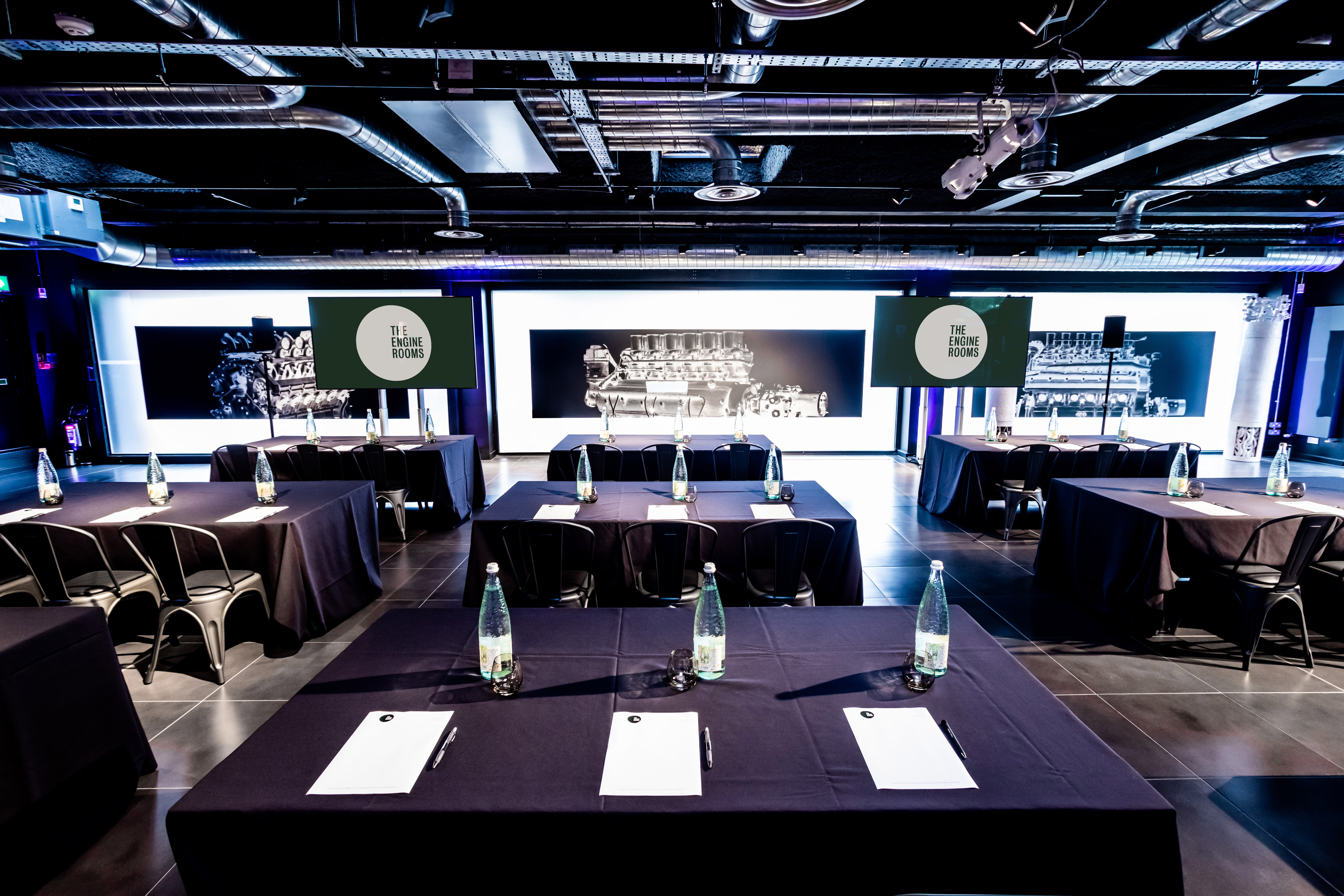 V12 Room meeting space with dark tables, ideal for professional events and presentations.