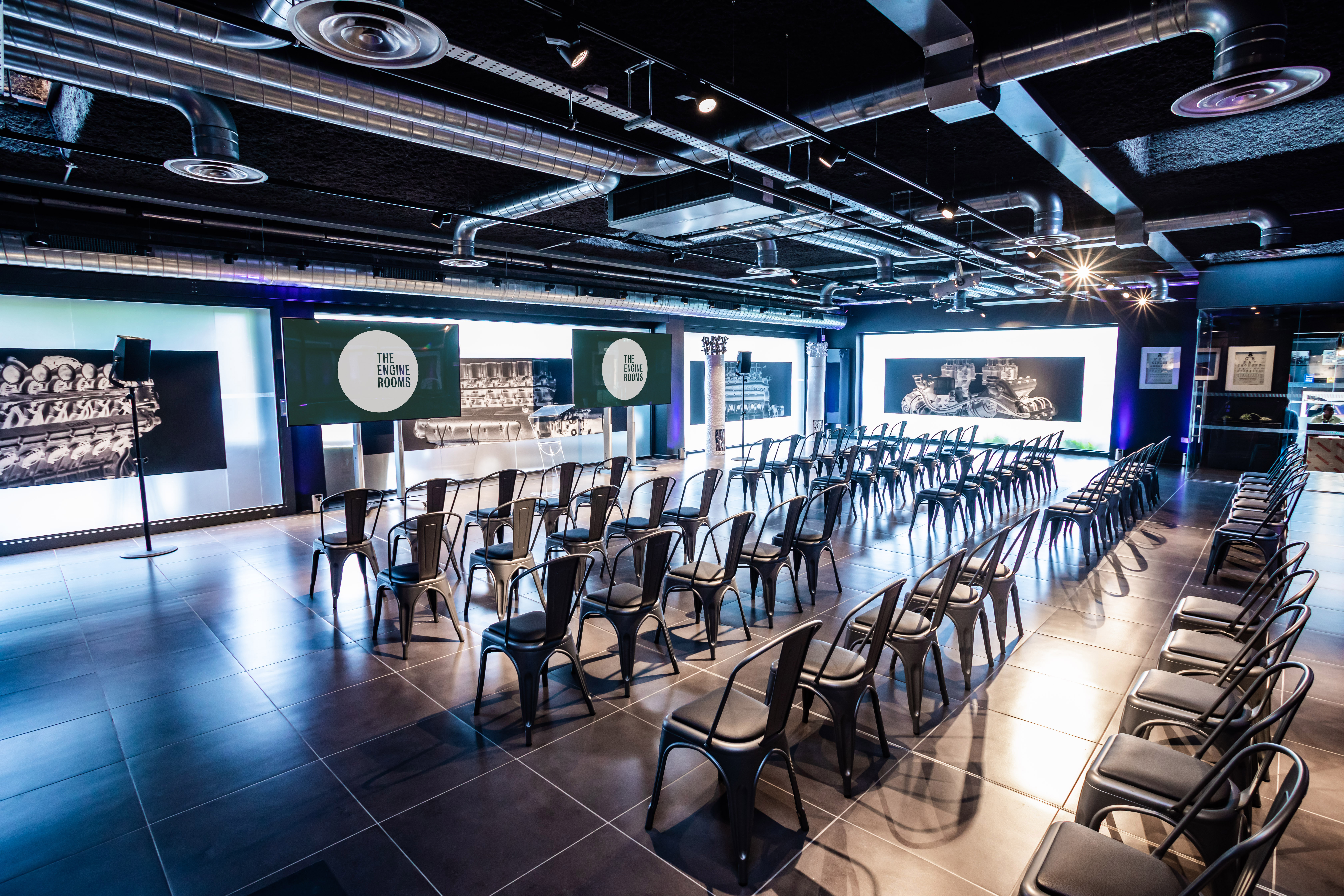 V12 Room event space with black chairs, ideal for corporate presentations and seminars.