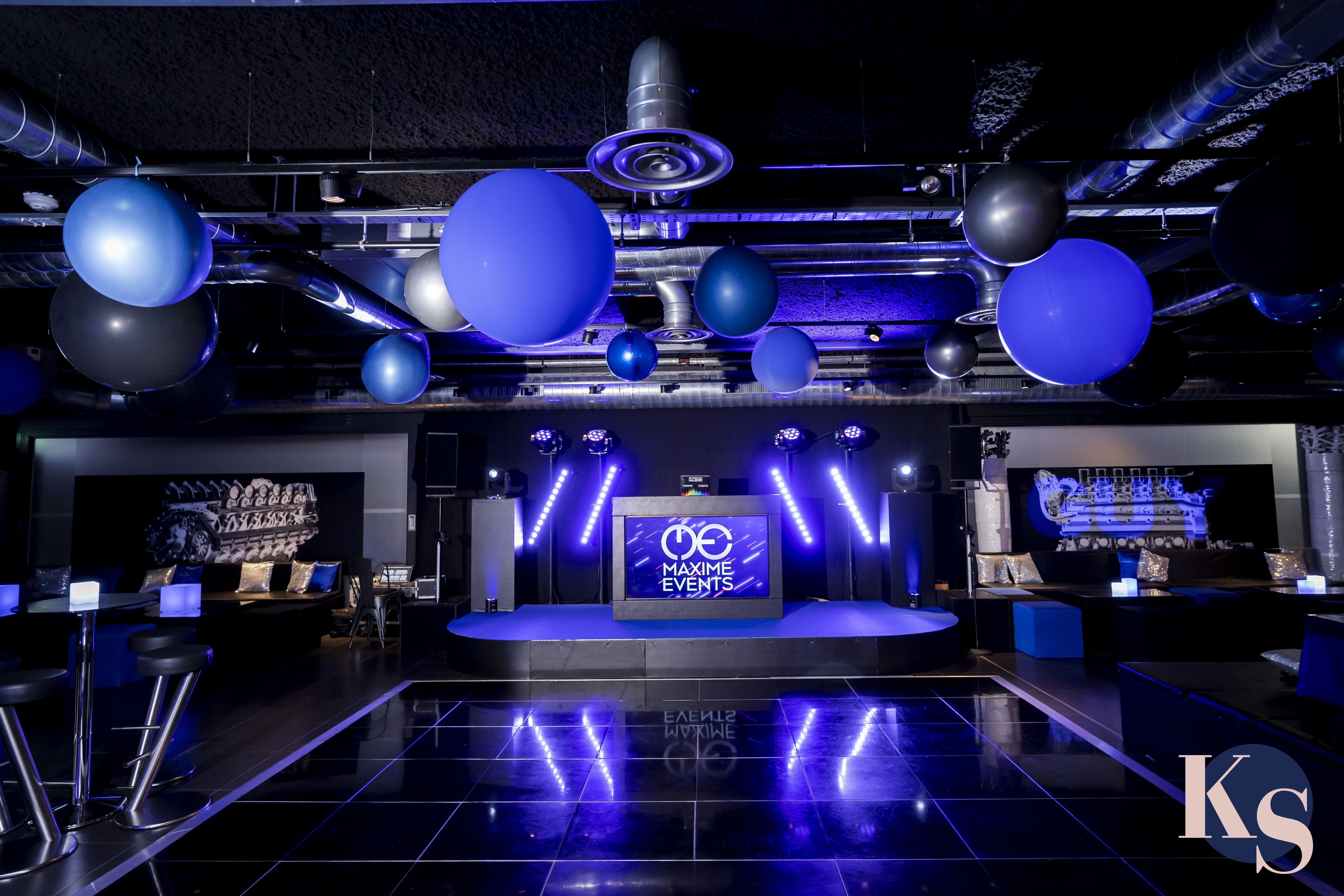 Modern event space with blue and black decor, ideal for presentations and celebrations.