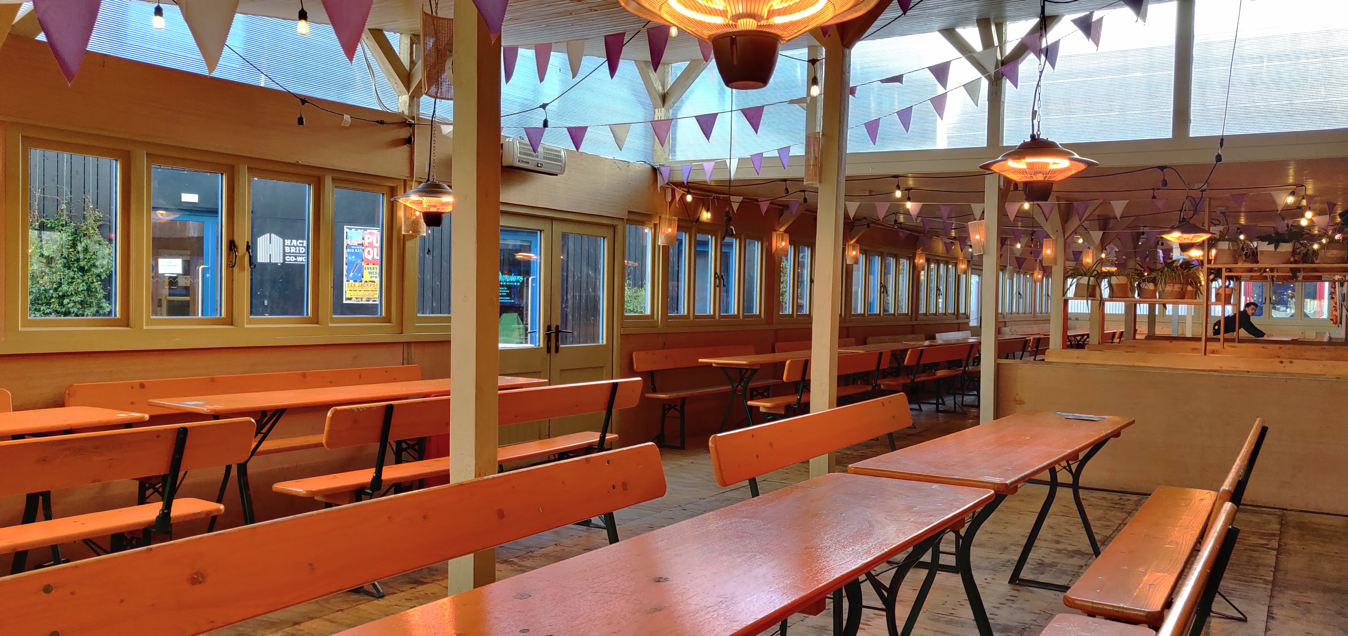 Log Cabin venue in Hackney Bridge with communal tables, ideal for workshops and events.