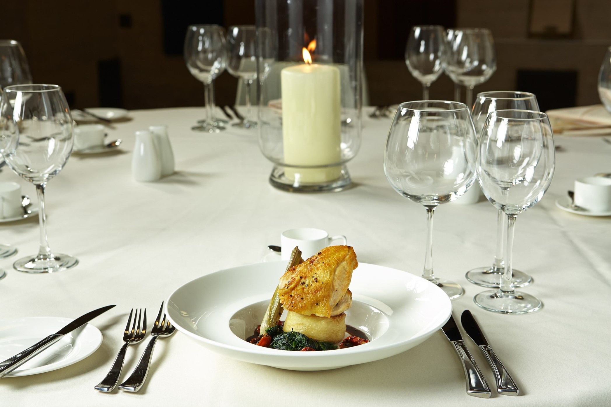 Elegant dining setup with candle centerpiece for formal events at University of London.
