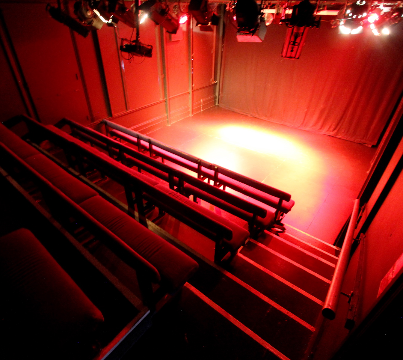 Black Box Theatre with red lighting, ideal for intimate workshops and performances.