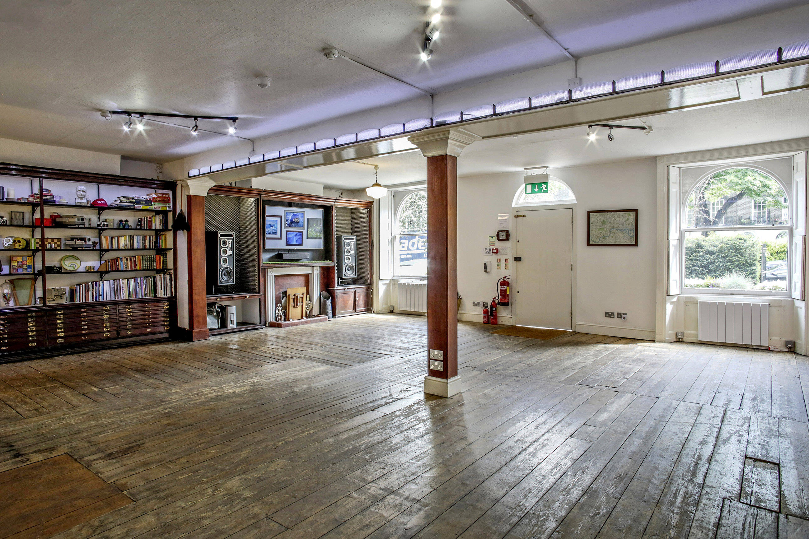 Versatile event space with wooden flooring, ideal for meetings and workshops.